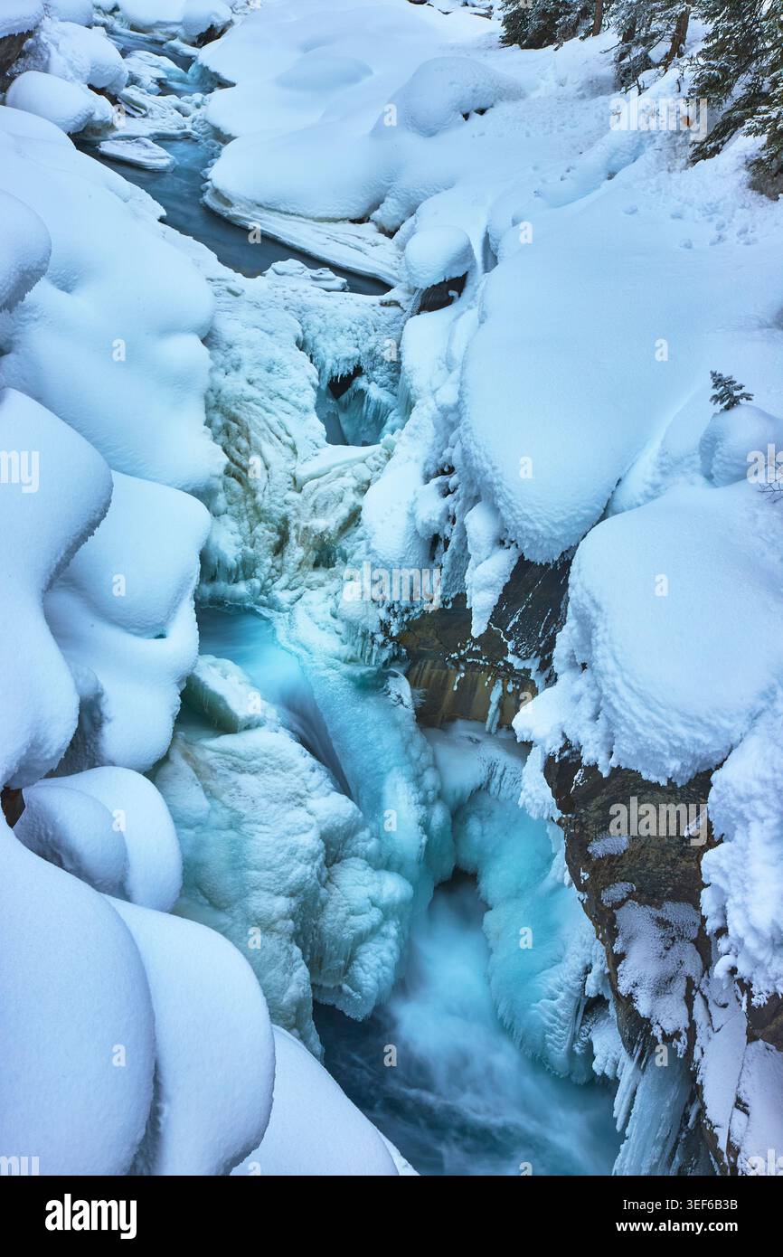 Chute d'eau gelée et canyon couvert de neige dans la nature sauvage d'hiver immaculée Banque D'Images