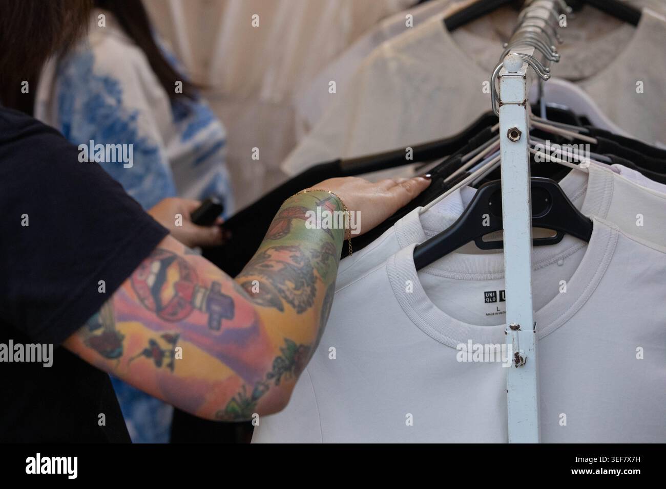 PHAYAO, THAÏLANDE-APR 11, 2026 : femmes mains shopping pour des vêtements dans le marché en plein air, la vie quotidienne dans le marché de rue asiatique, gros plan, Chiang Kham. Banque D'Images
