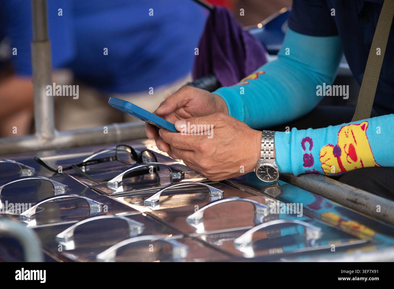 PHAYAO, THAÏLANDE-APR 11, 2026 : fournisseur de produits alimentaires utilisant un smartphone, activité quotidienne sur smartphone, routine urbaine moderne, gros plan, Chiang Kham. Banque D'Images