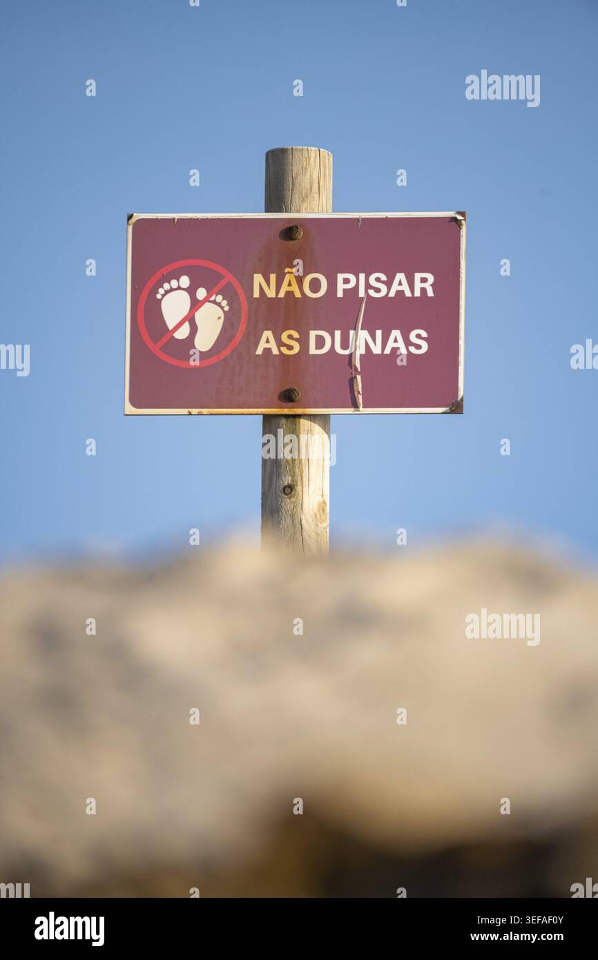 Panneau écrit en portugais interdisant de marcher sur les dunes Banque D'Images