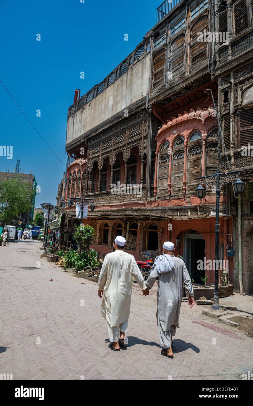Vue sur la maison historique dans la vieille ville Peshawar, mettant en valeur l'architecture locale et la vie quotidienne des résidents marchant ensemble Banque D'Images