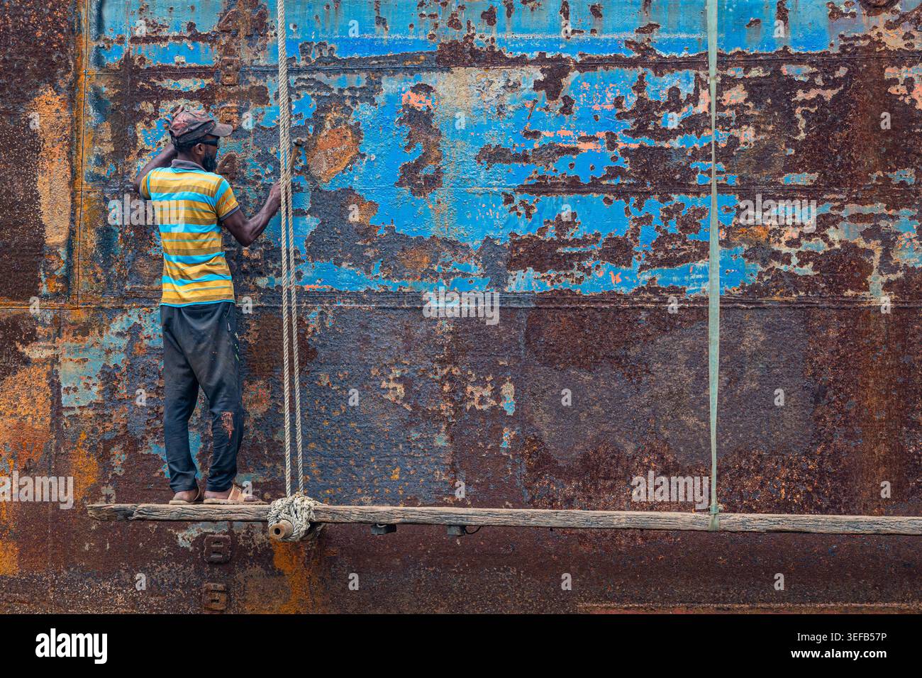 Des hommes réparent un bateau dans un chantier naval alors qu'ils travaillent avec diligence à Dhaka, au Bangladesh, se concentrant sur la tâche à accomplir Banque D'Images