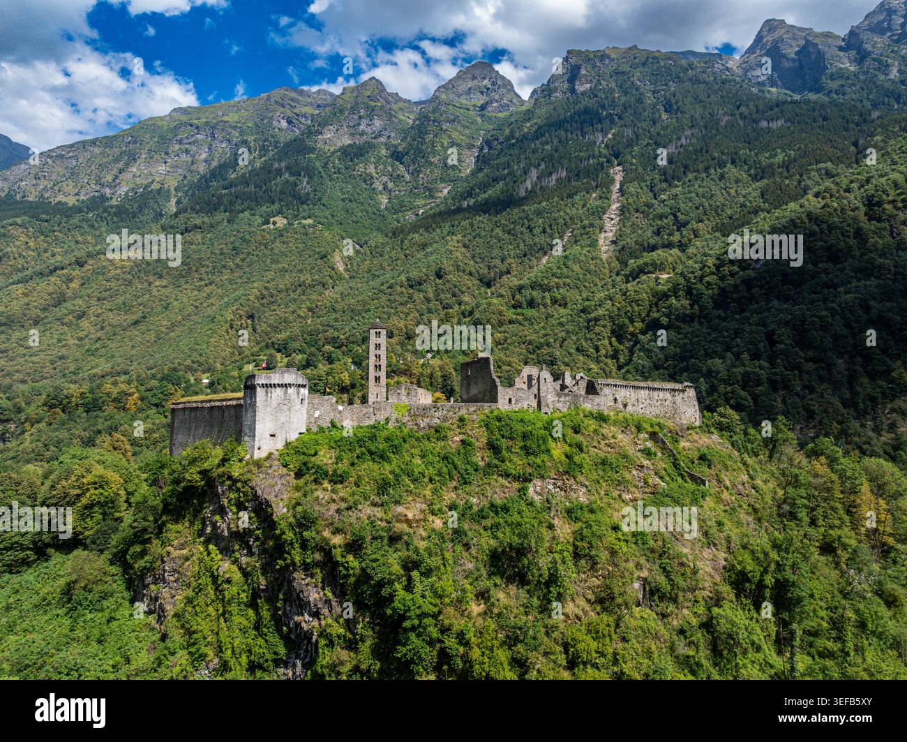 Le château de Mesocco se dresse sur une colline entourée de forêts verdoyantes et de montagnes en Suisse Banque D'Images
