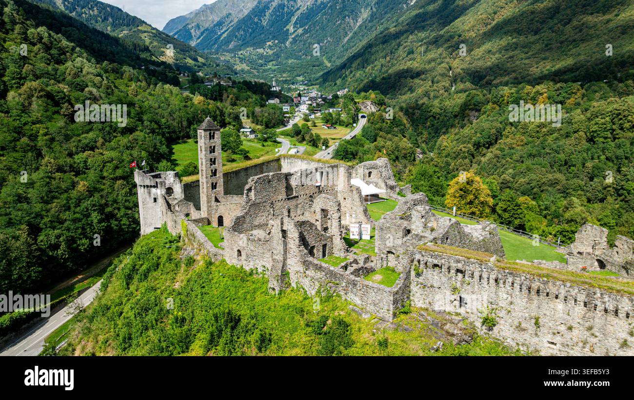 La vue aérienne montre les ruines du château de Mesocco entourées de montagnes et de verdure en Suisse Banque D'Images