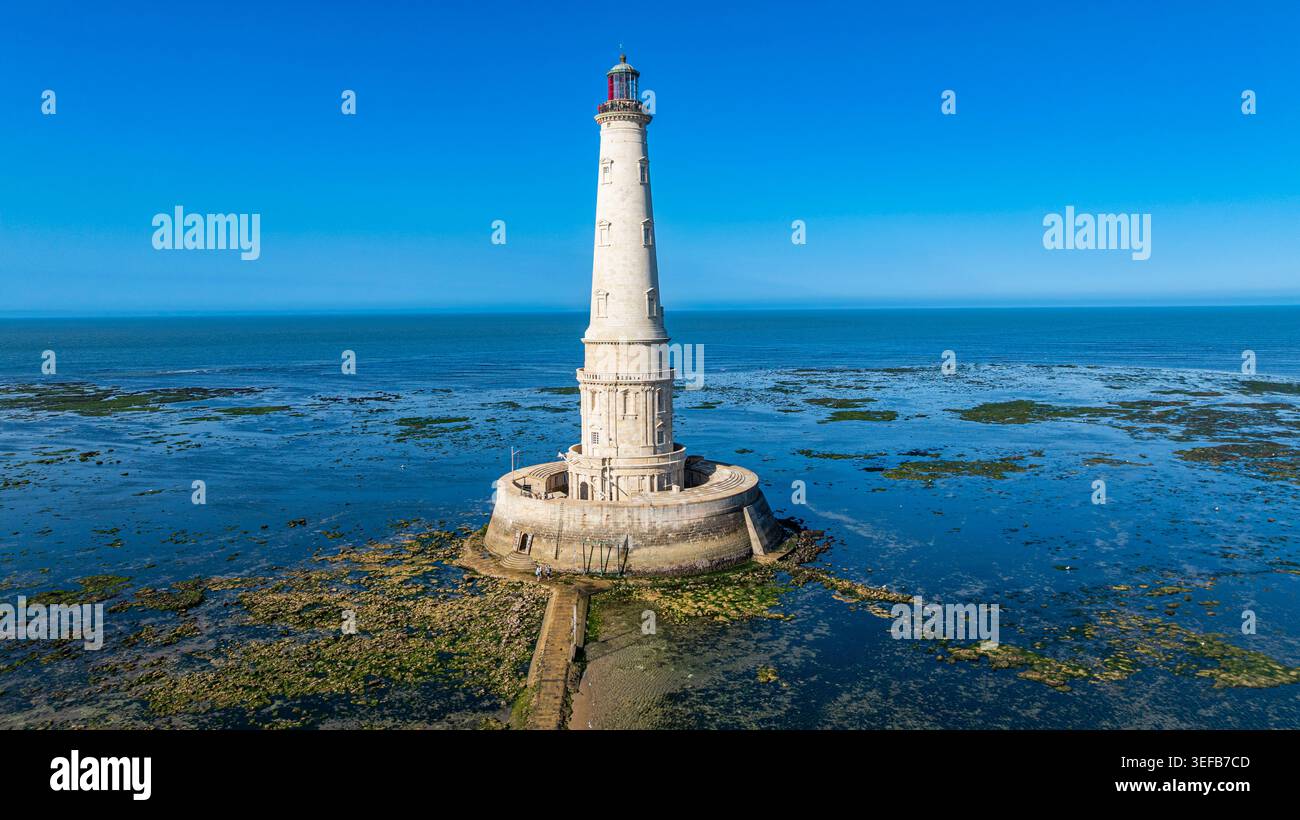 Vue aérienne du phare de Cordouan entouré d'eaux calmes et de rochers en France Banque D'Images