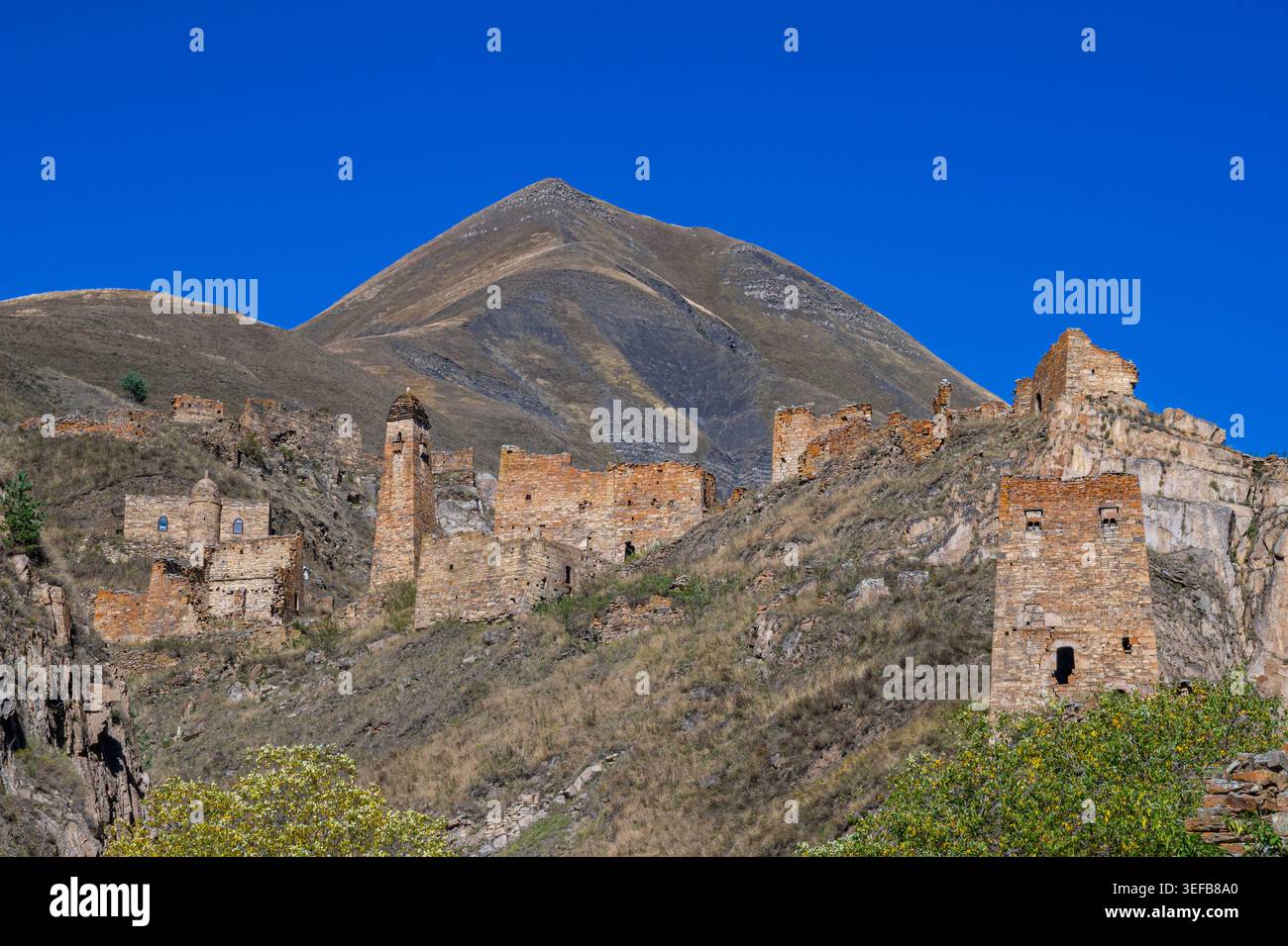 Explorer un village de montagne abandonné en Tchétchénie avec des ruines et une montagne lointaine dans le ciel Banque D'Images