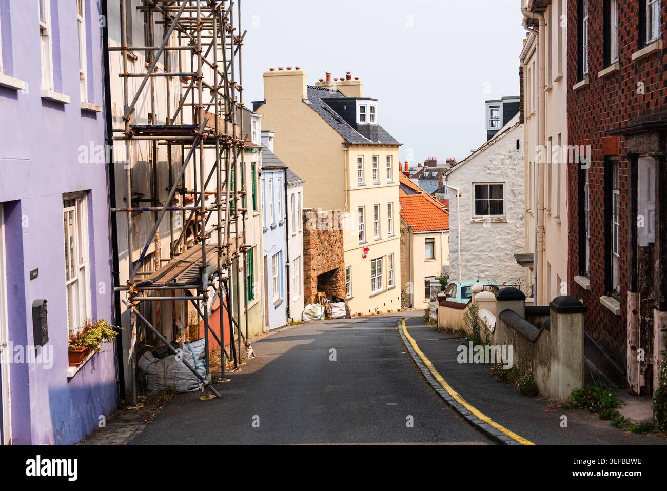 Rue pavée étroite dans le complexe Peter Port avec une lumière chaude éclairant les bâtiments Banque D'Images