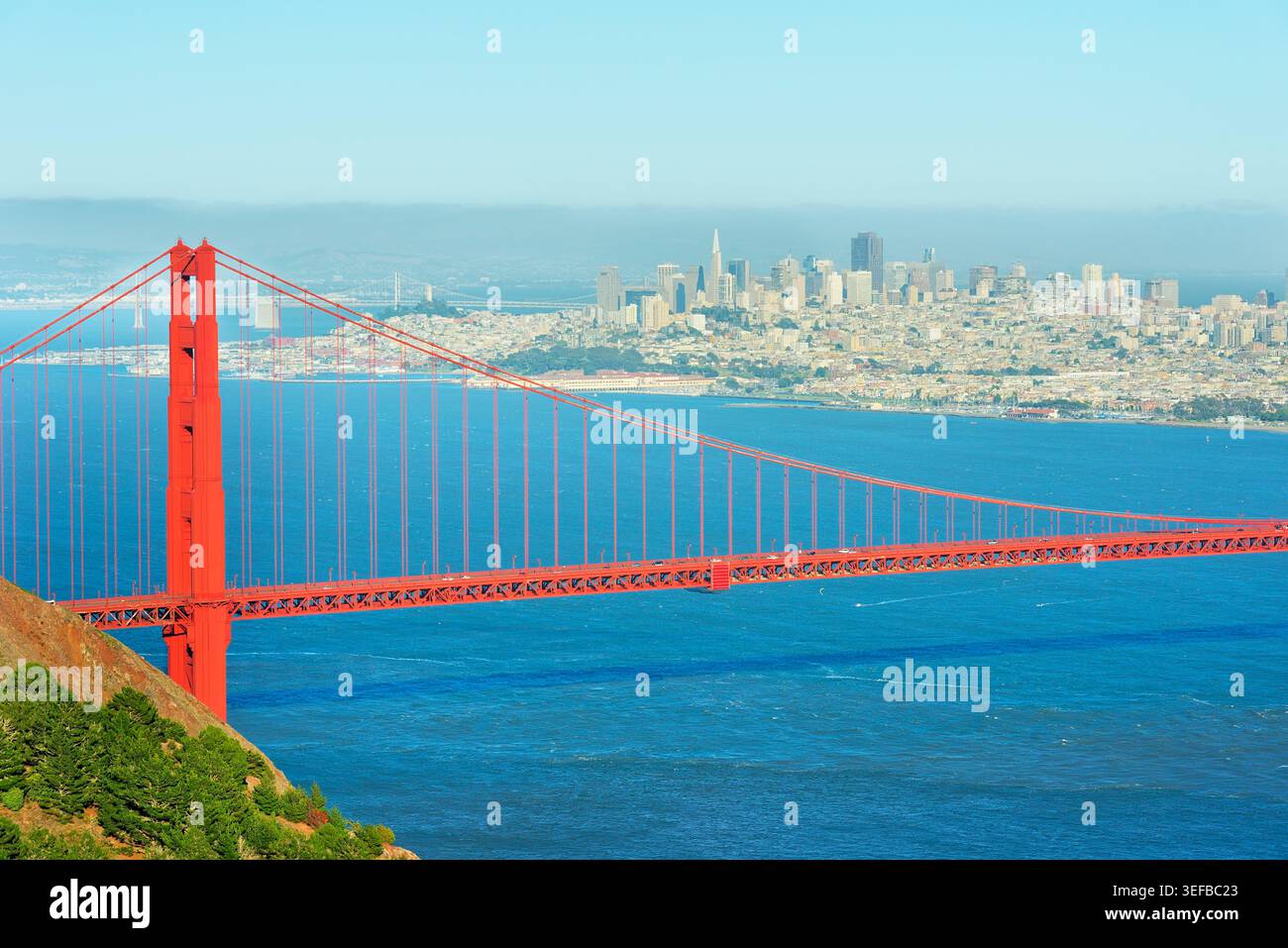 Vue sur le Golden Gate Bridge et le quartier financier de San Francisco avec un ciel bleu clair et des eaux calmes en arrière-plan Banque D'Images