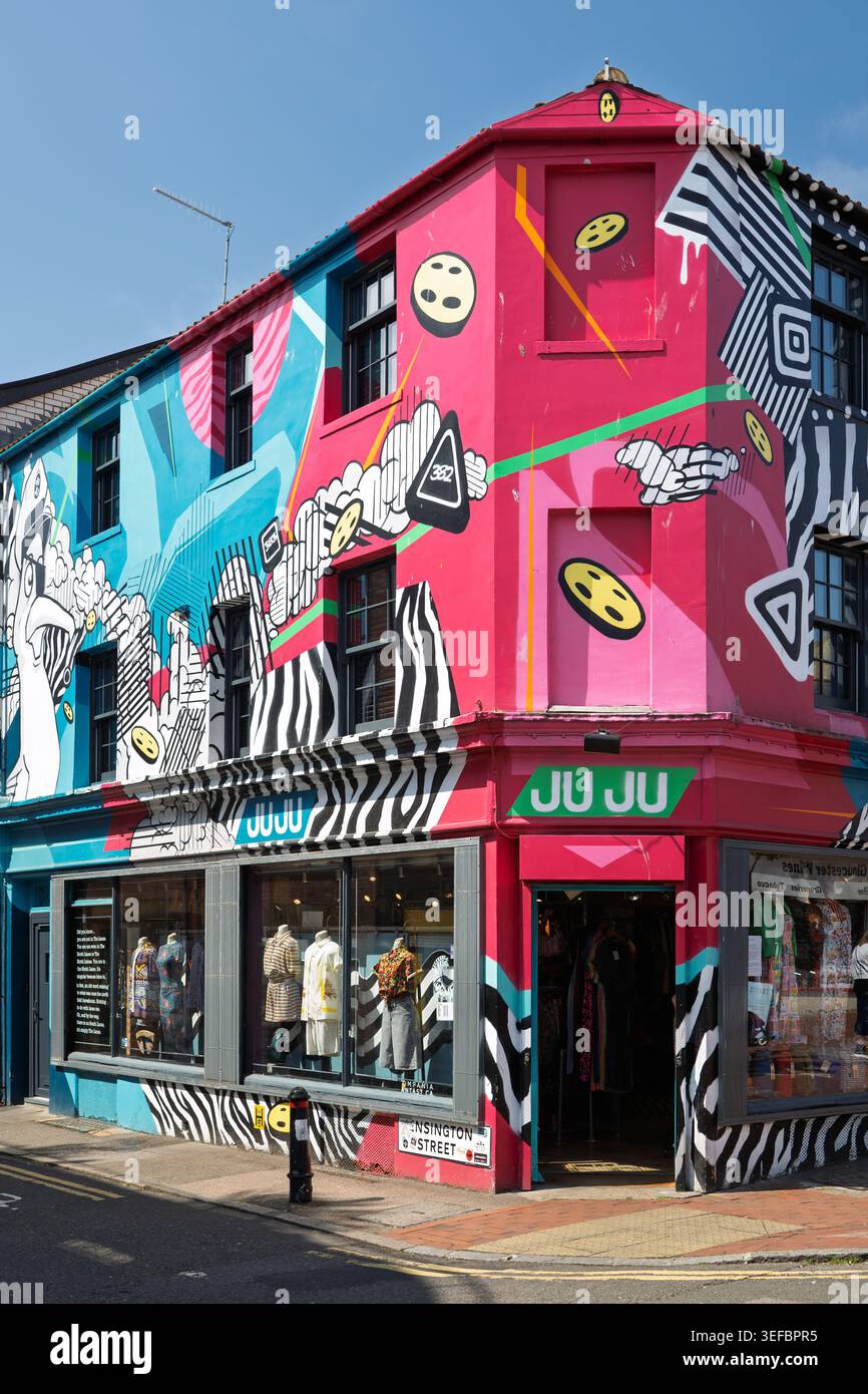 Vue extérieure d'un bâtiment rose vif orné de Street art urbain coloré et de peintures murales graffiti à Brighton Banque D'Images