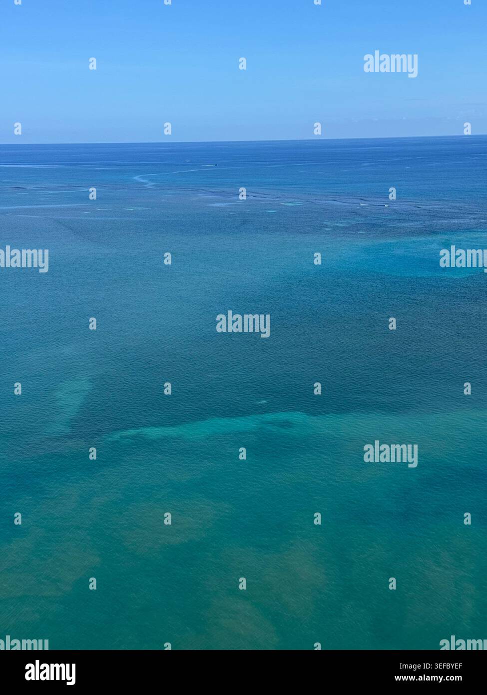 Vue aérienne de dessus de l'eau de mer turquoise cristalline des Caraïbes au-dessus des récifs coralliens en Jamaïque. - Image de stock capturée avec un smartphone