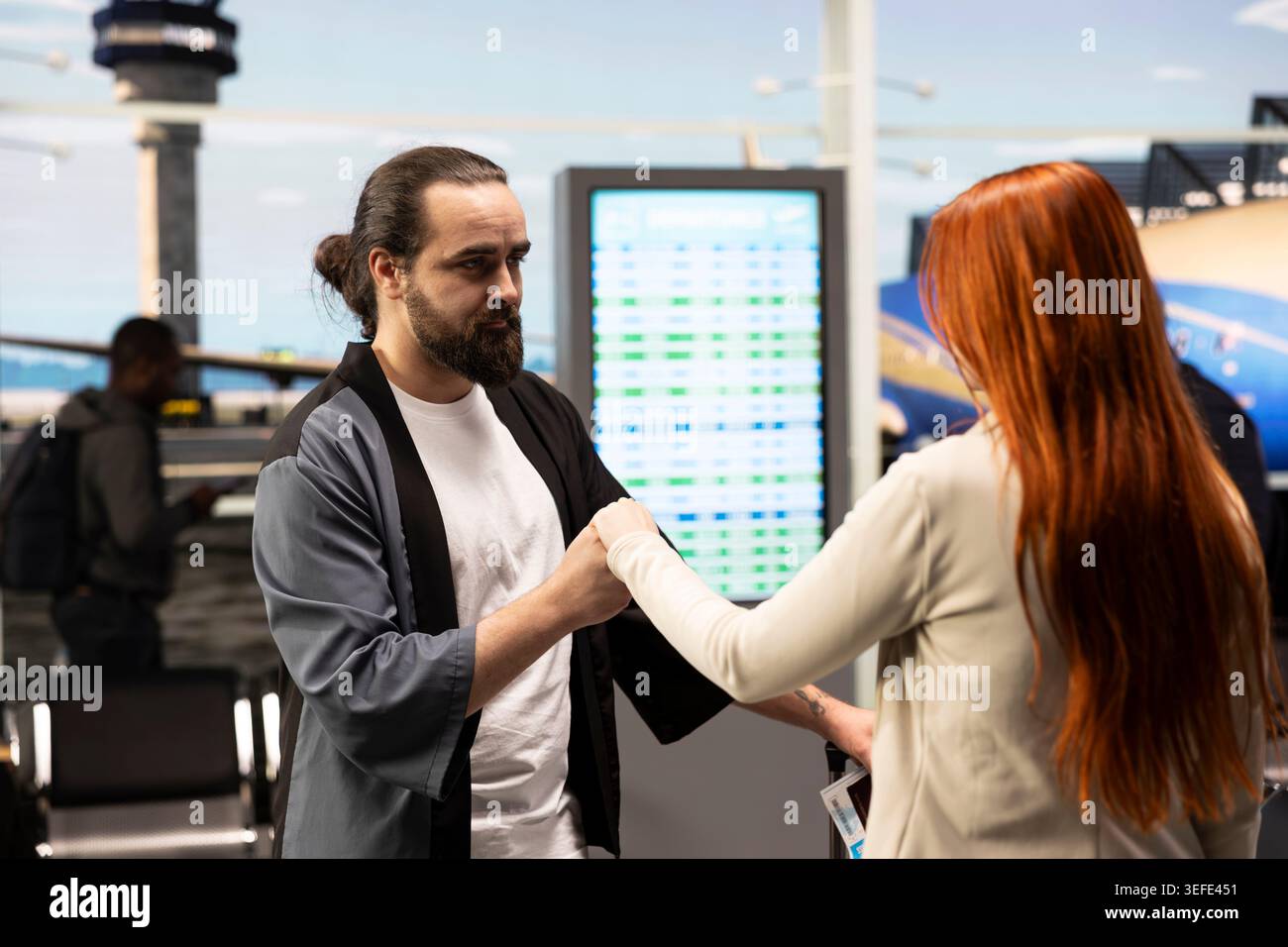Doux couple amoureux partageant un moment intime dans le salon de l'aéroport, caressant et se tenant la main. Petit ami et petite amie exprimant la passion et l'affection profonde, belle histoire d'amour à la réunion. Banque D'Images