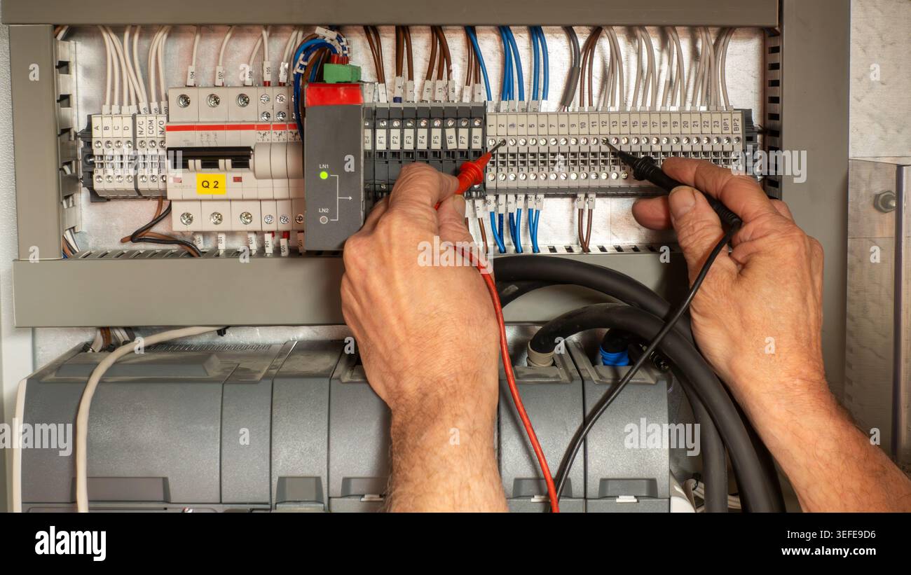 Ingénieur spécialisé dans les tests électriques et la mise en service enquêtant sur un défaut sur un commutateur de transfert automatique. Générateur de secours d'urgence pour él Banque D'Images