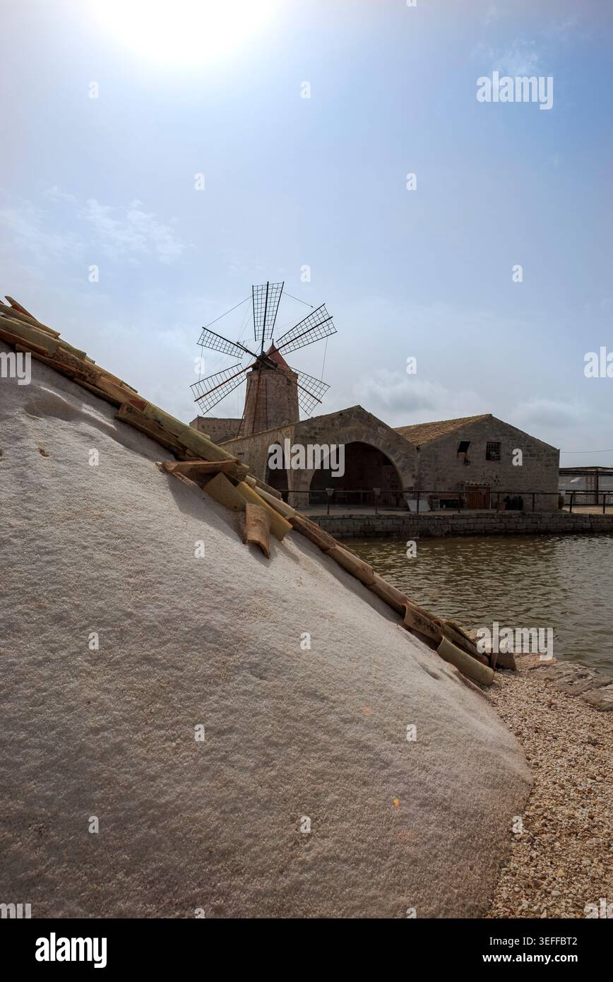 D'imposants monticules de sel de mer récolté empilés à côté des étangs d'évaporation de la saline de Trapani, en Sicile. Banque D'Images