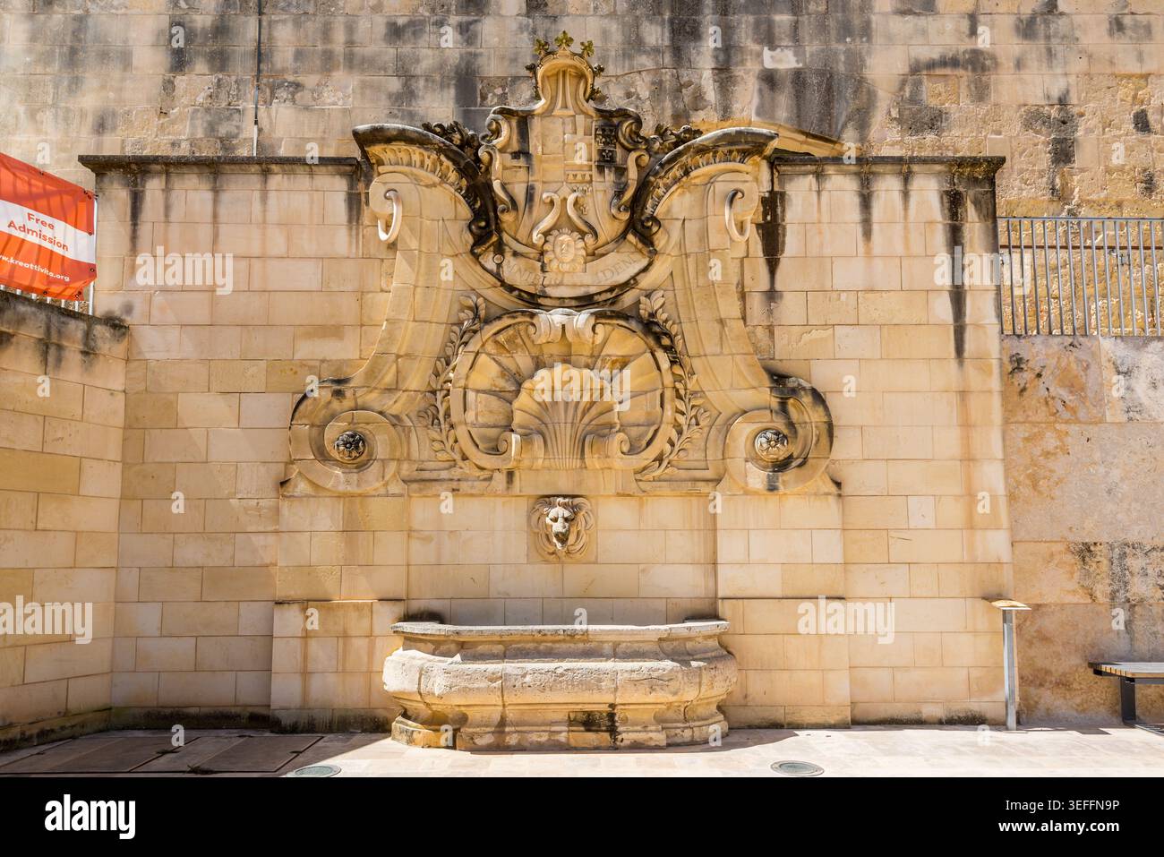 La Valette, Malte – 16 mai 2025 : fontaine de Wignacourt, monument baroque avec des sculptures en pierre ornées et un bec à tête de lion, debout dans le HEA historique Banque D'Images