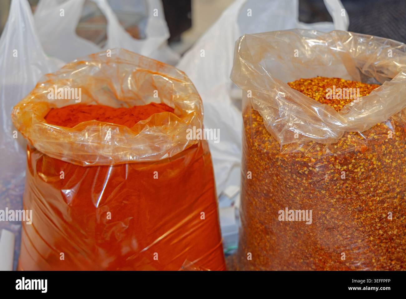 Grande quantité de poudre de Chili rouge flocons moulus piments séchés aux épices dans des sacs en vrac Banque D'Images