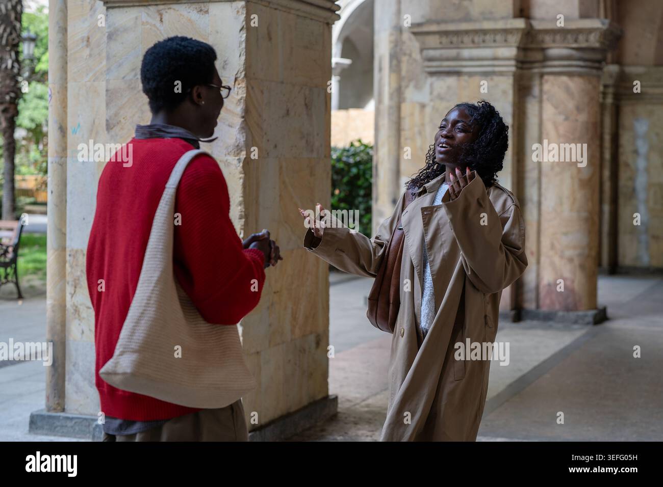 Joyeux surpris afro-américain homme et femme amis se rencontrant dans la rue de la ville. Banque D'Images