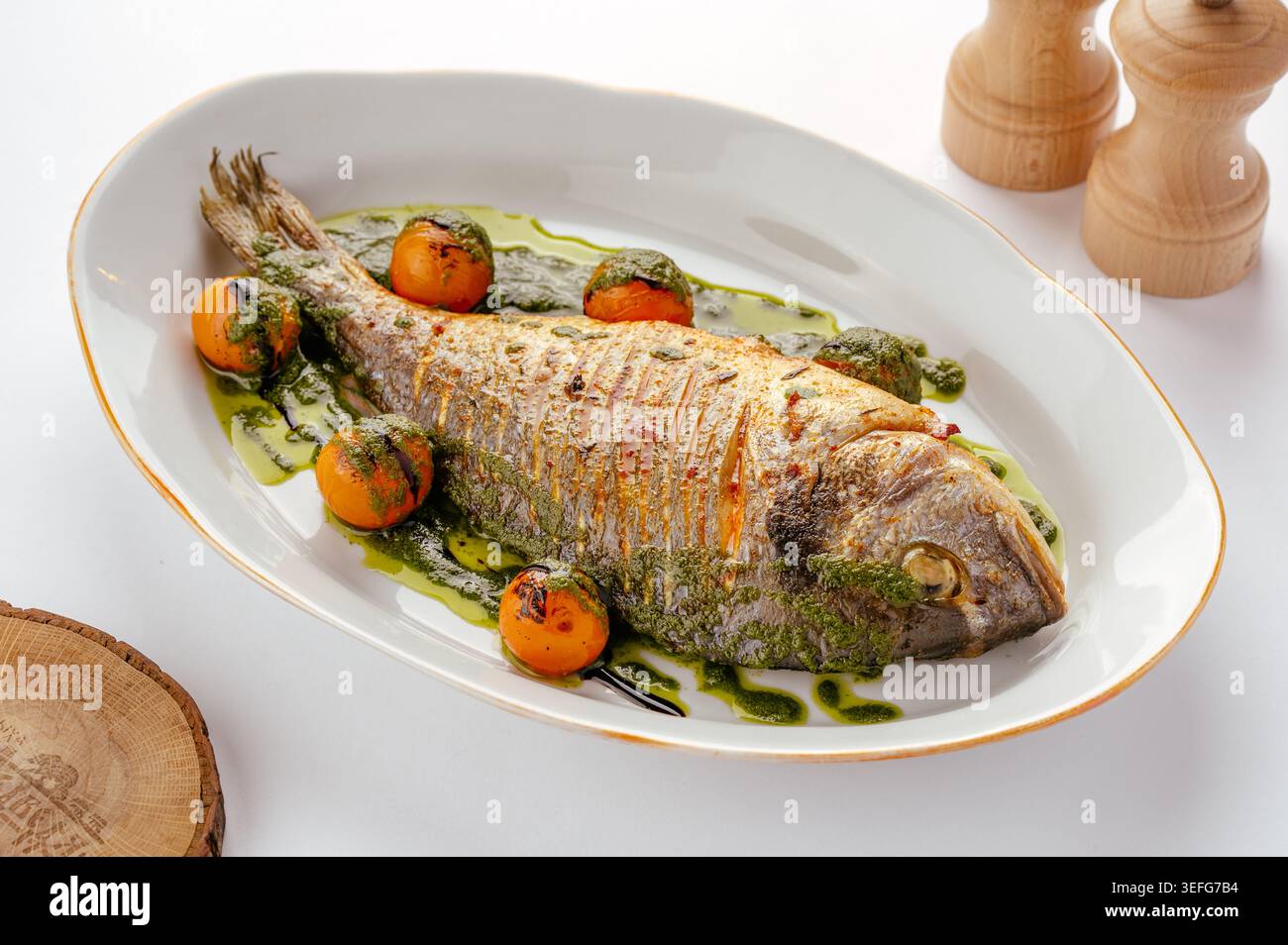 Poisson dorado entier grillé avec tomates cerises rôties Banque D'Images