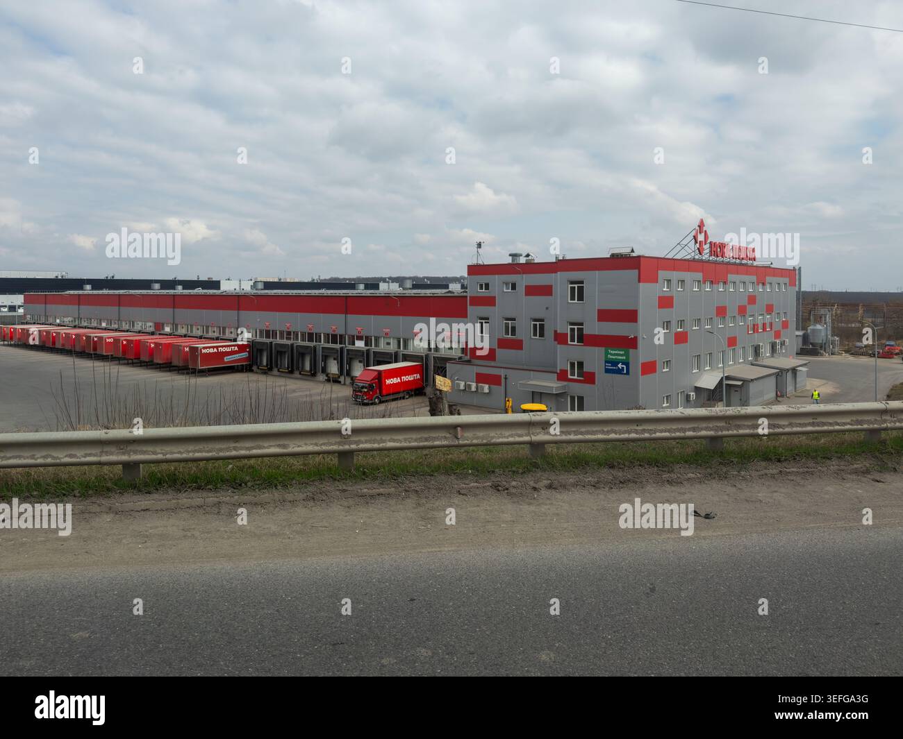 Khmelnytskyi, Ukraine - 30 mars 2026 : bâtiment d'entrepôt Nova Poshta avec plusieurs quais de chargement et des camions de fret rouges, représentant la supp. Mondiale Banque D'Images