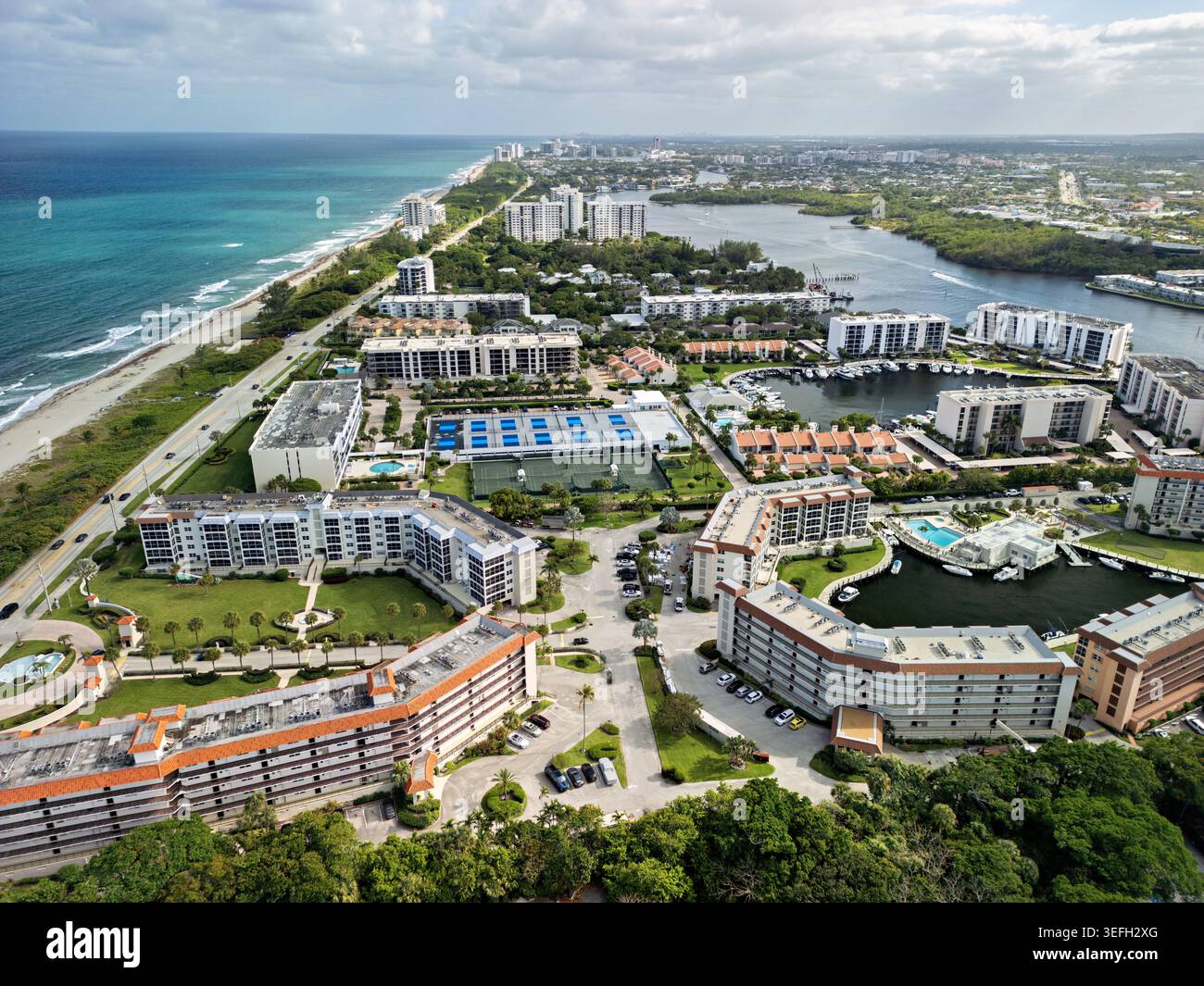 Vue aérienne des complexes résidentiels côtiers avec courts de tennis, piscines et un port de plaisance près de la plage de sable et l'océan bleu à Boca Raton, Flori Banque D'Images