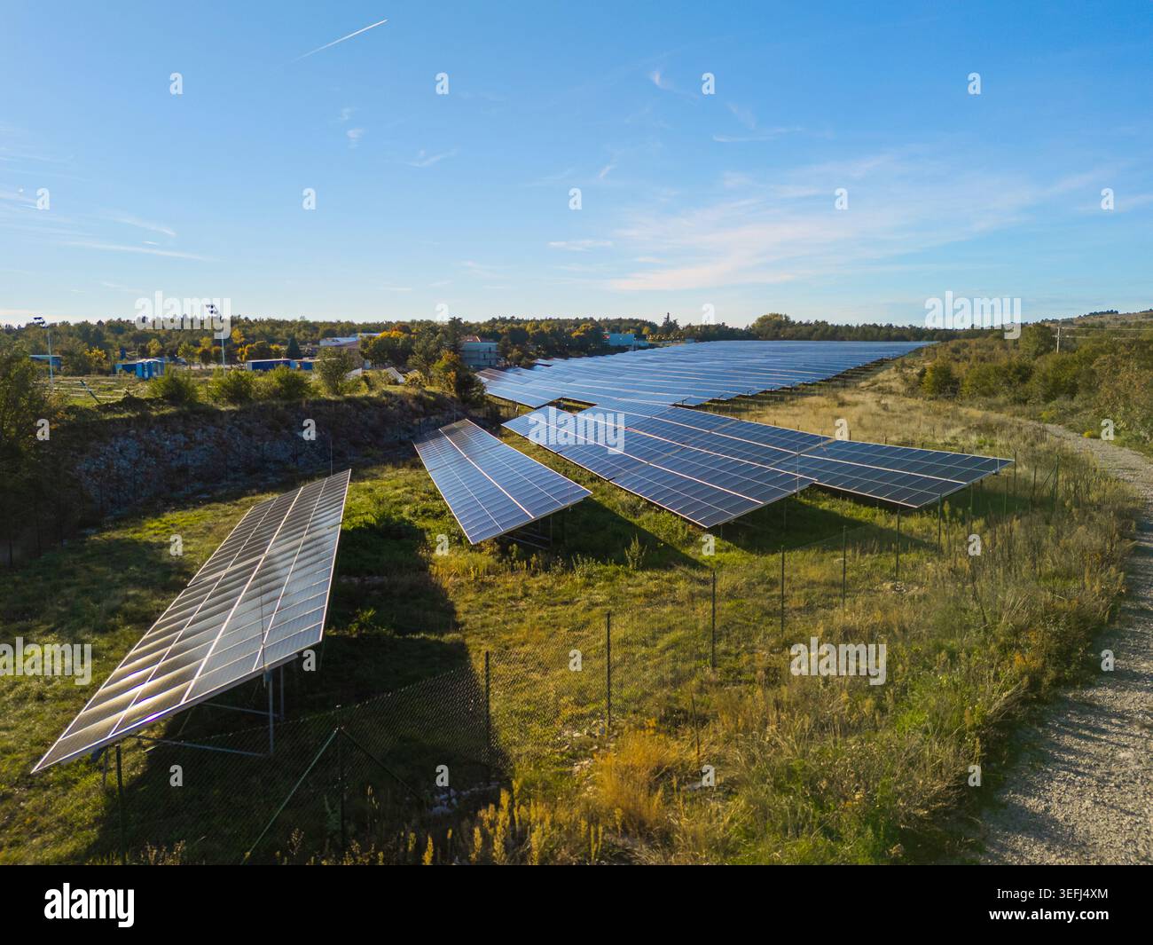 Vue aérienne d'une ferme solaire avec des rangées de panneaux photovoltaïques dans une zone rurale. Banque D'Images