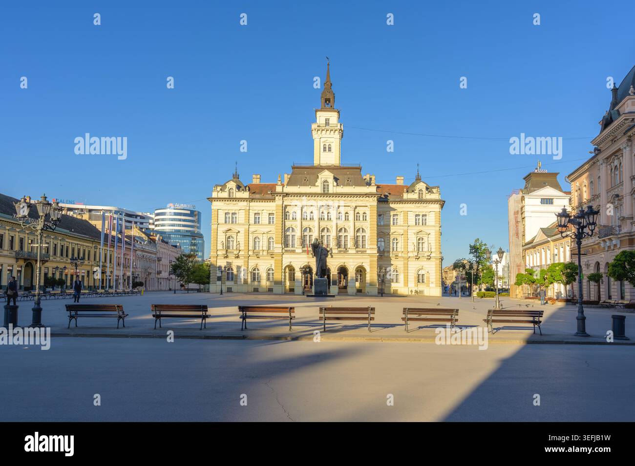 L'hôtel de ville de Novi Sad se trouve bien en vue sur la place de la liberté, présentant l'architecture européenne historique sous un ciel bleu clair. Cette capture de paysage urbain Banque D'Images