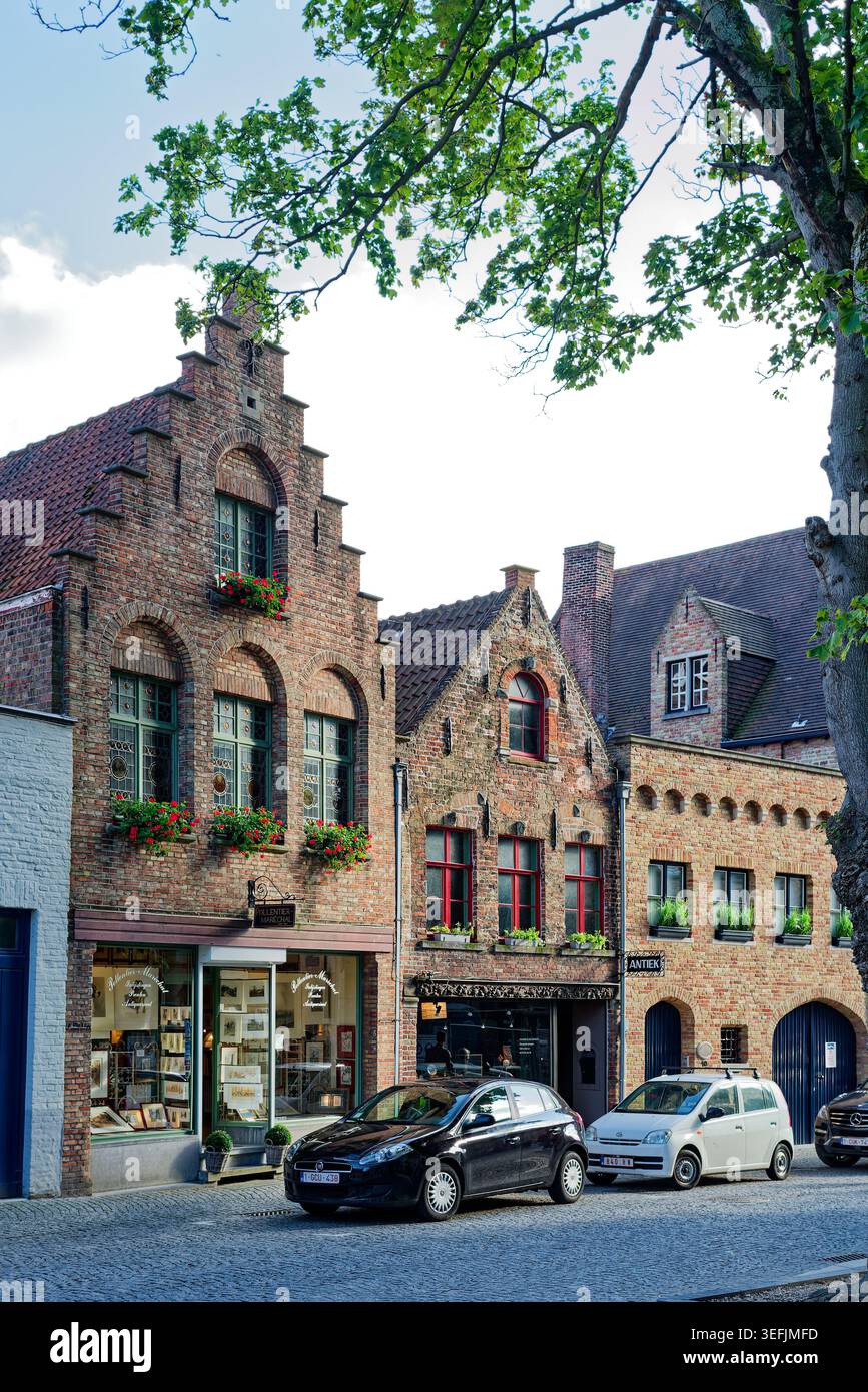 Bruges, Belgique. 13 août 2017 : boutiques historiques et maisons à pignon en escalier le long d'une rue dans le centre médiéval de Bruges. Banque D'Images