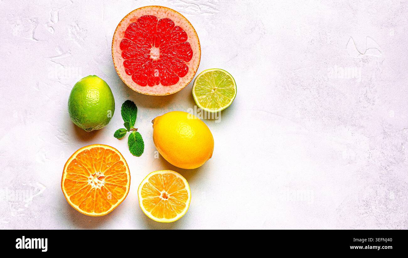 Citron frais, orange, pamplemousse, citron vert, feuilles vertes sur fond clair, vue de dessus. Concept de jus d'agrumes, vitamine C, fruits. Banque D'Images