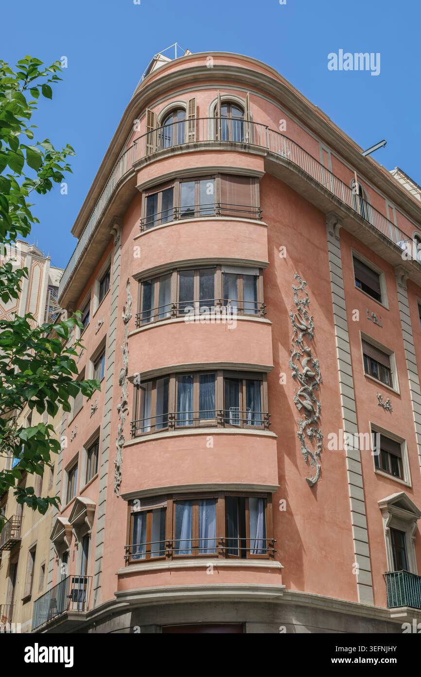Façade de bâtiment rose vintage avec fenêtres incurvées et reliefs ornementaux Sgraffito, architecture méditerranéenne, Barcelone, Catalogne, Espagne Banque D'Images