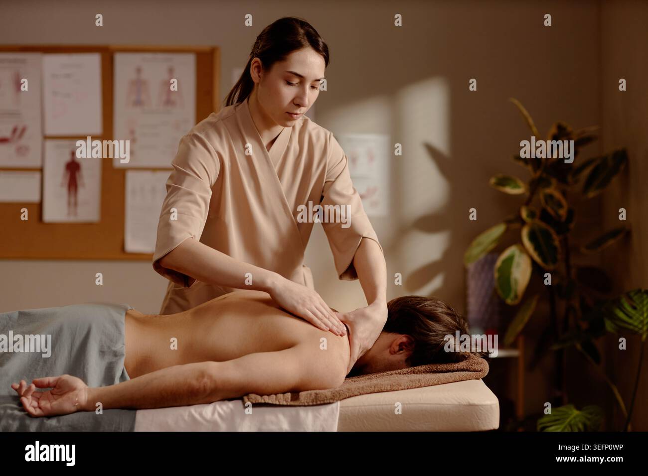 Femme adulte massothérapeute traitant le client dans la clinique de bien-être Banque D'Images