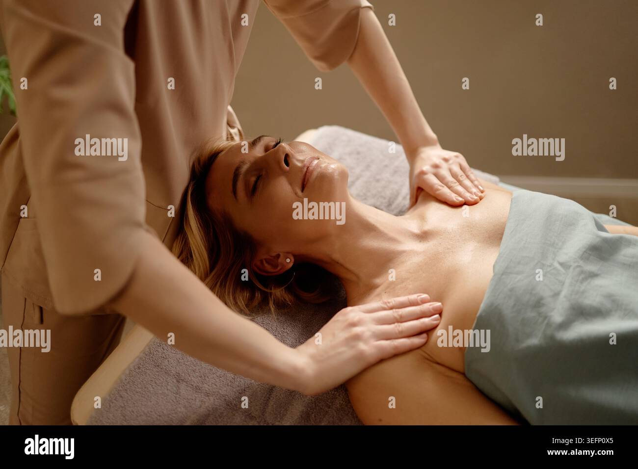 Femme adulte recevant un massage de poitrine pour le soulagement du stress dans Spa Banque D'Images
