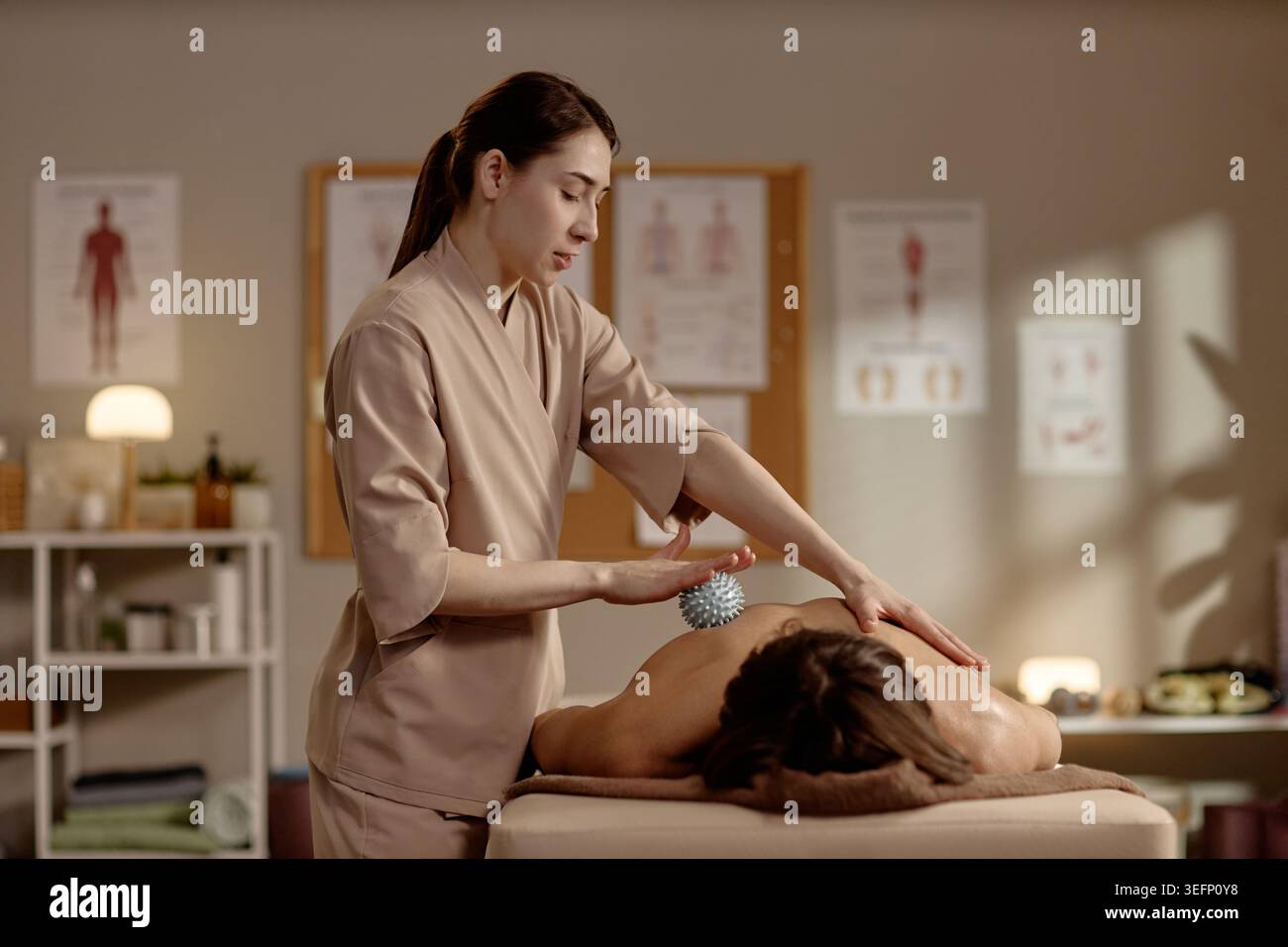 Thérapeute femme adulte effectuant un massage du dos dans la clinique de bien-être Banque D'Images