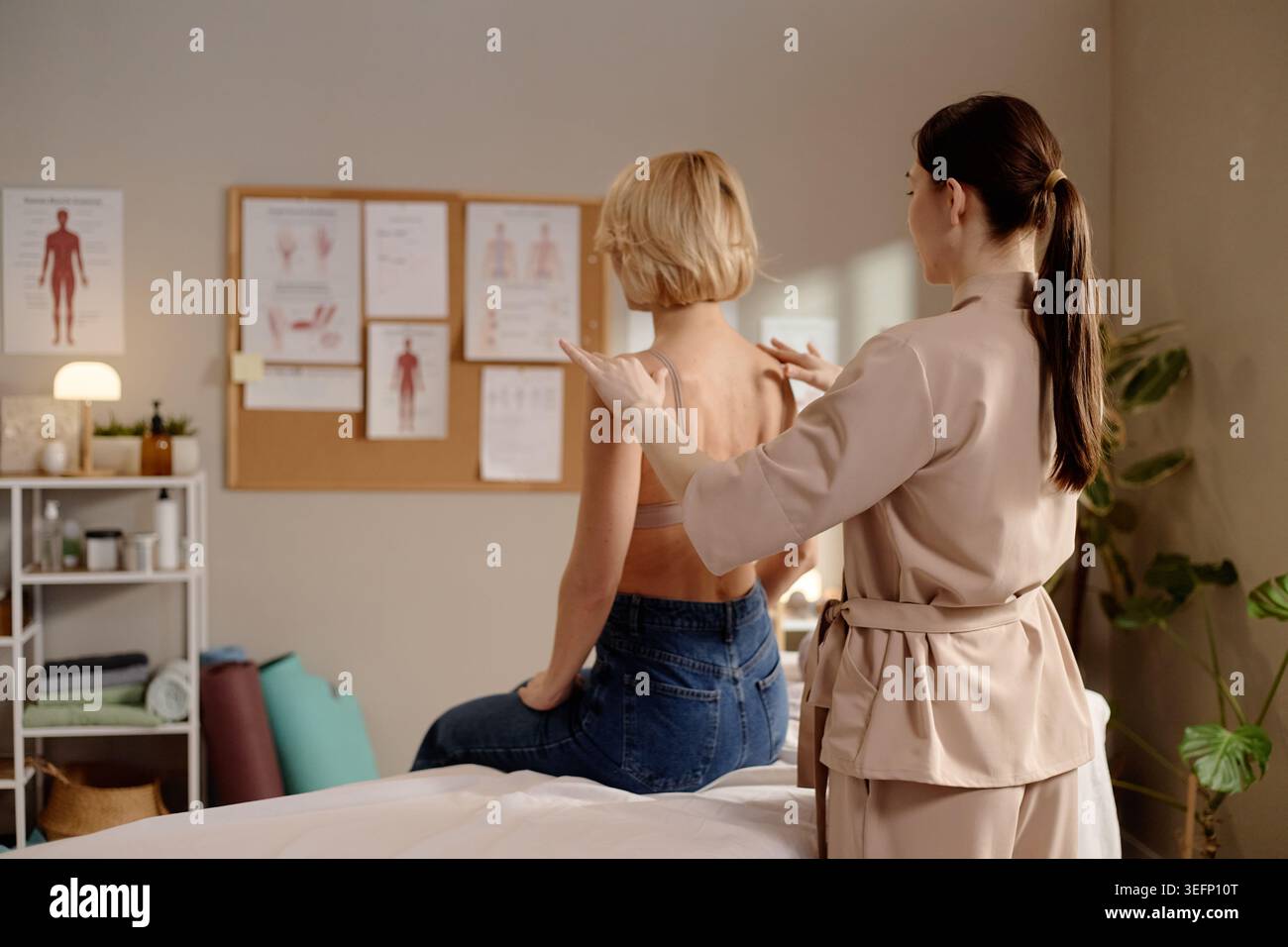 Thérapeute de femme adulte évaluant la femme pour la mobilité de l'épaule Banque D'Images