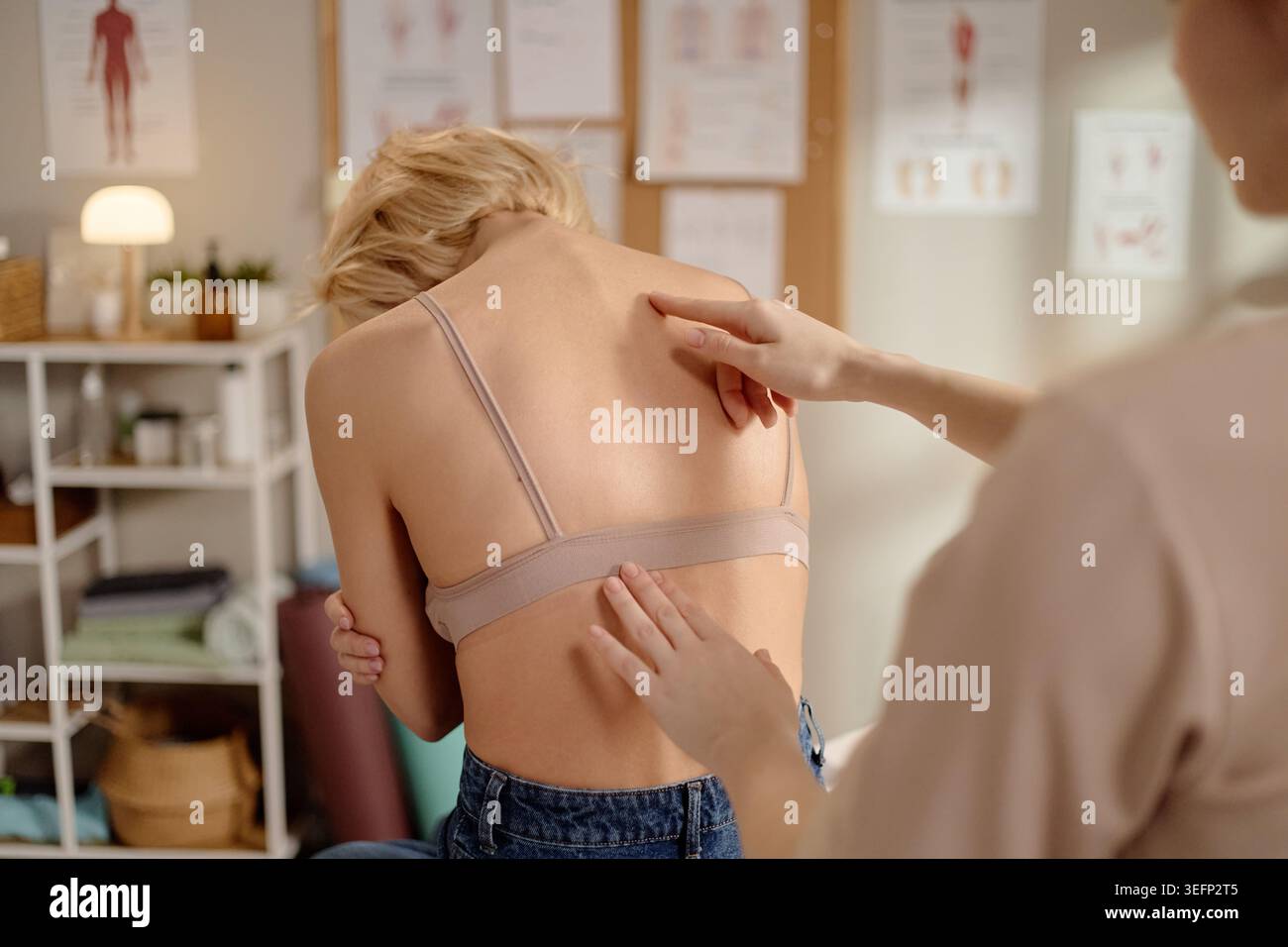 Femme adulte recevant un examen du dos pendant l'évaluation de la posture Banque D'Images