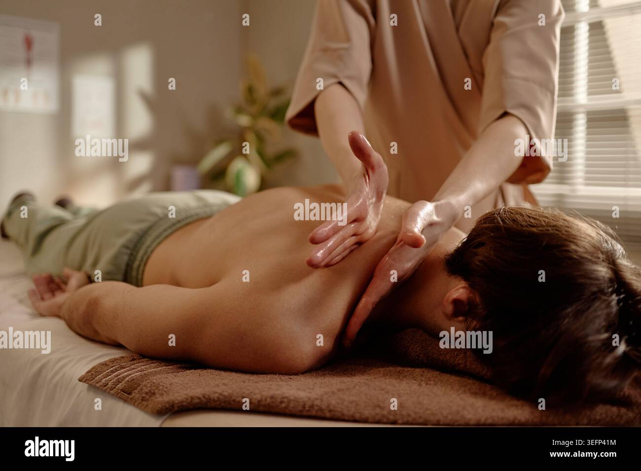 Homme adulte recevant le corps supérieur du dos pour récupération musculaire Banque D'Images