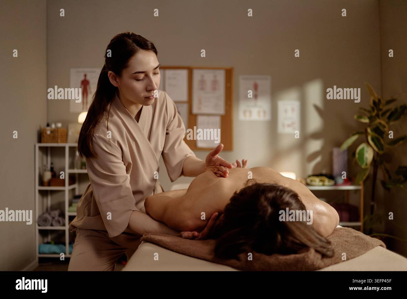 Thérapeute femme adulte effectuant la thérapie manuelle sur le client homme Banque D'Images