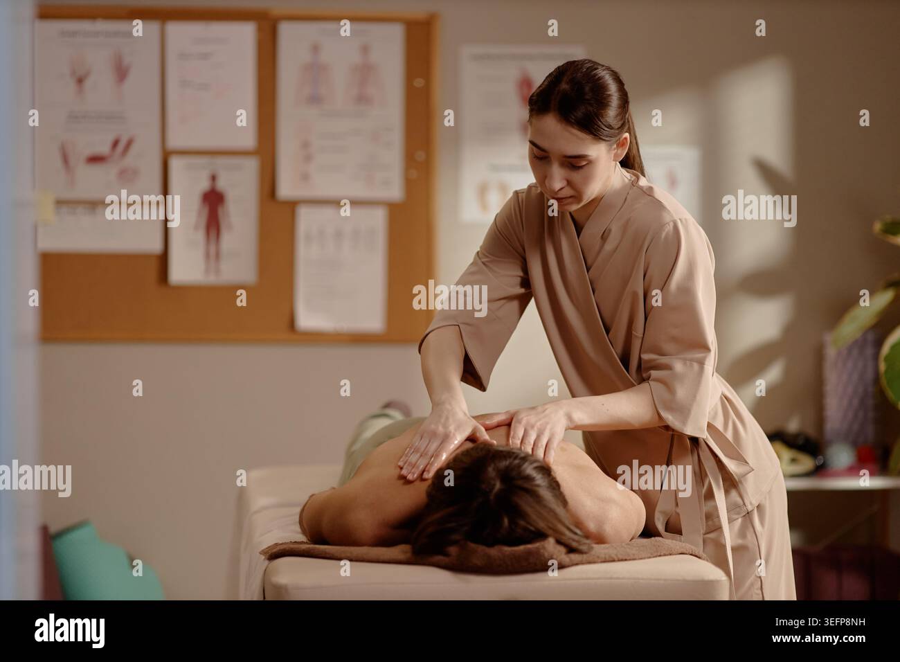 Thérapeute femme adulte effectuant un massage des épaules pour soulager le stress Banque D'Images
