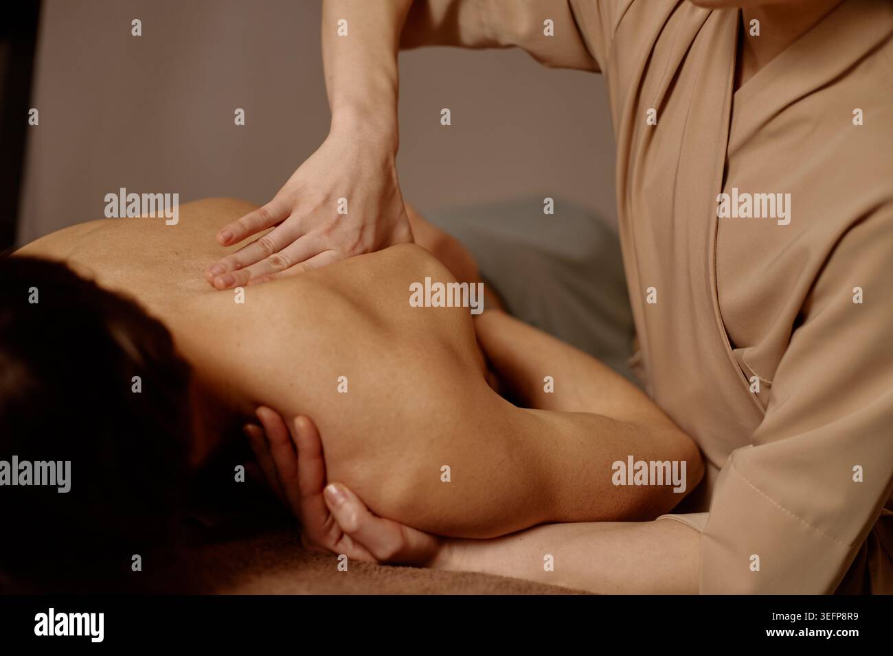 Homme adulte recevant un massage des épaules pour soulager la tension musculaire Banque D'Images