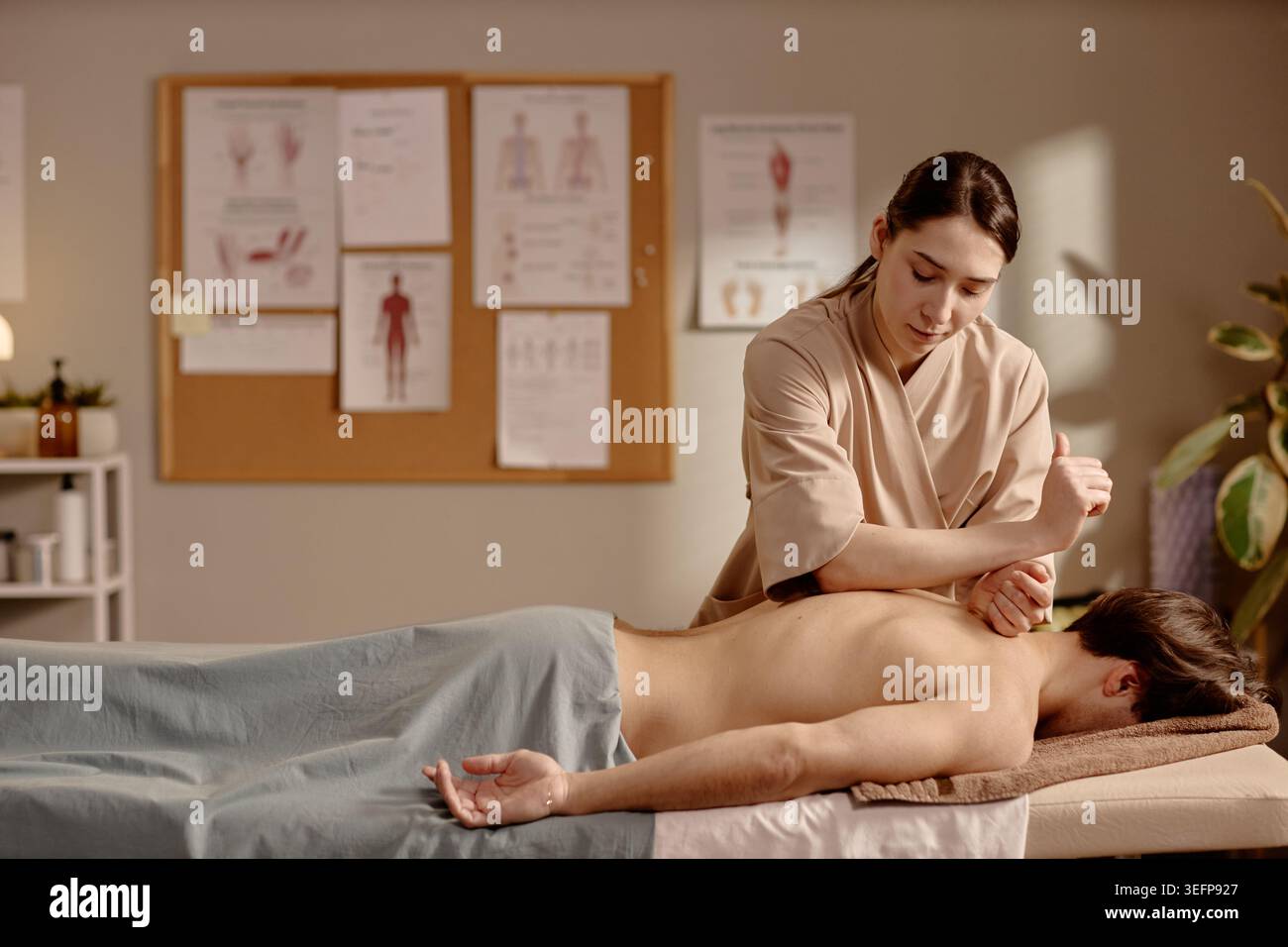 Thérapeute femme adulte effectuant un traitement de massage des tissus profonds Banque D'Images