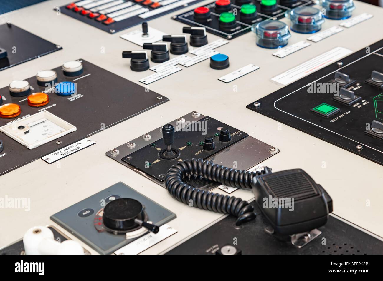 Panneau de commande industriel avec boutons commutateurs joystick et microphone radio dans un pont de navire ou un centre de commande d'usine Banque D'Images