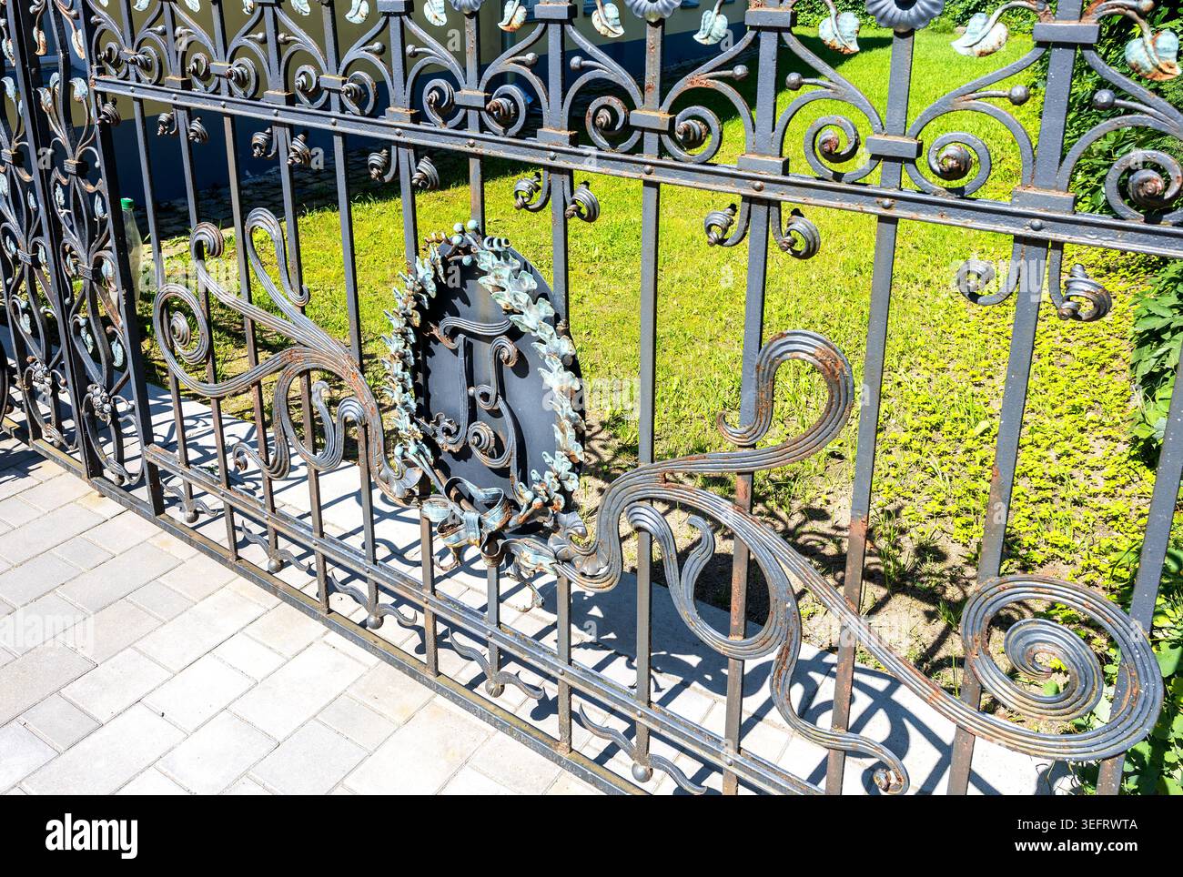 Borovichi, Russie - 17 juillet 2025 : grille forgée en métal antique avec des éléments de décoration sur une rue de la ville. Grille de clôture en fer Banque D'Images