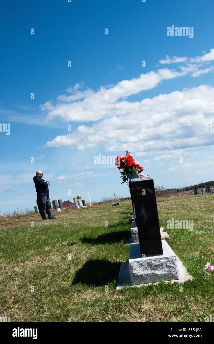 Le poids tranquille de la perte : un moment de solitude et de deuil dans un cimetière extérieur. Banque D'Images