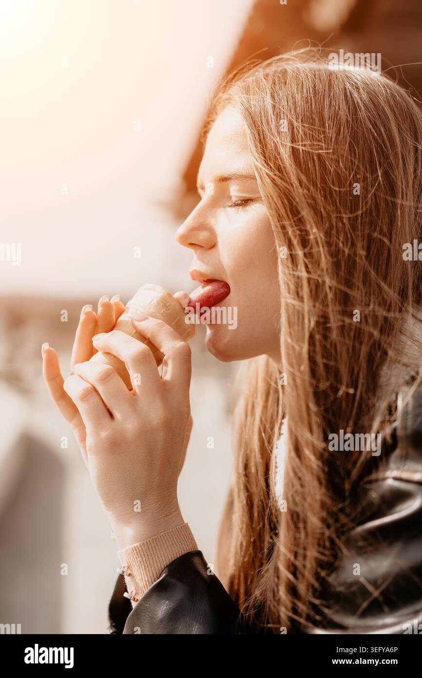 Femme crème glacée léchant jeune femme léchant cône de crème glacée fraise dans une tasse de gaufre sur une journée ensoleillée lumineuse à l'extérieur Banque D'Images