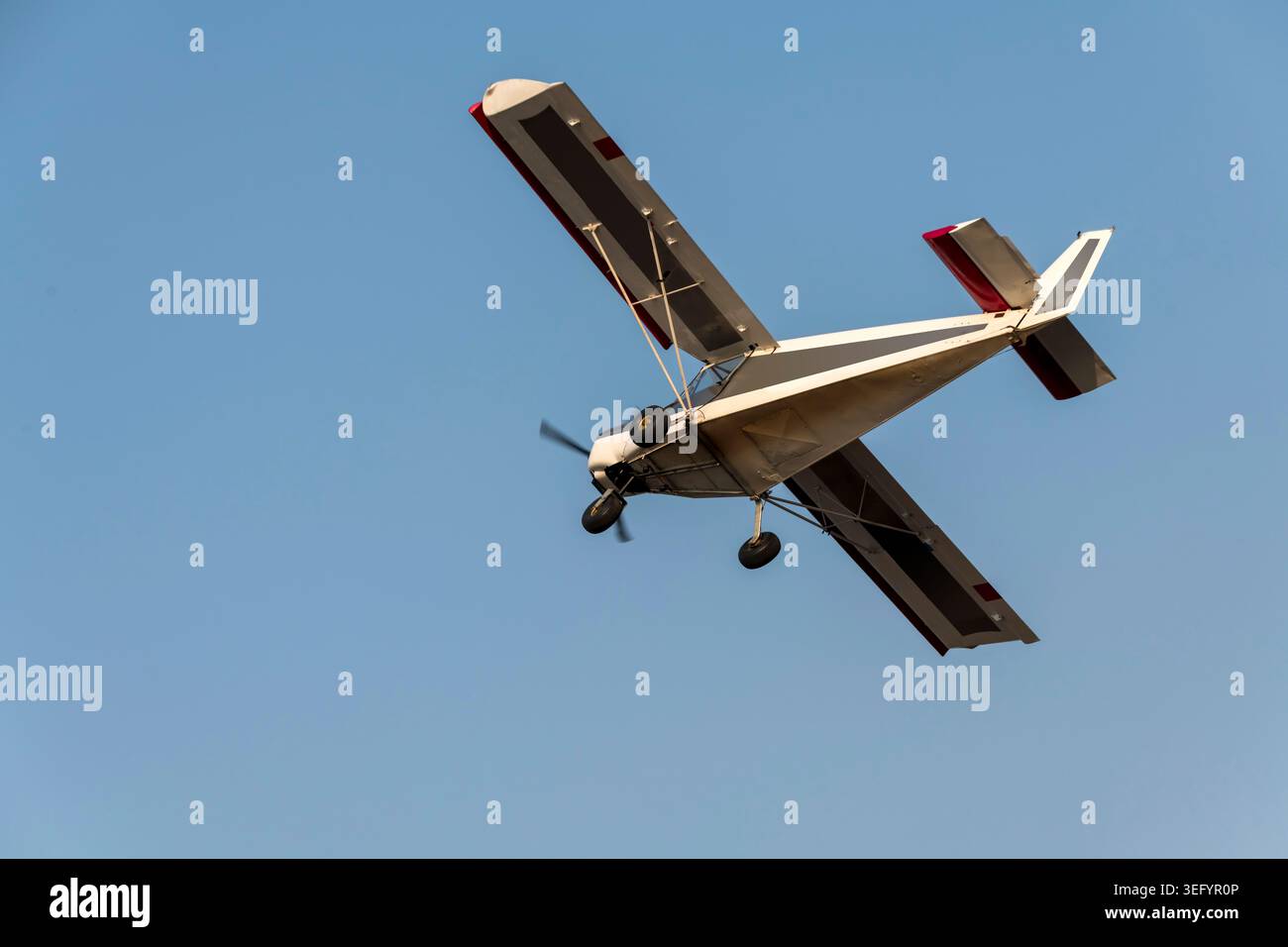 Vieil avion à hélice classique tournant et s'envolant sur un ciel bleu isolé Banque D'Images
