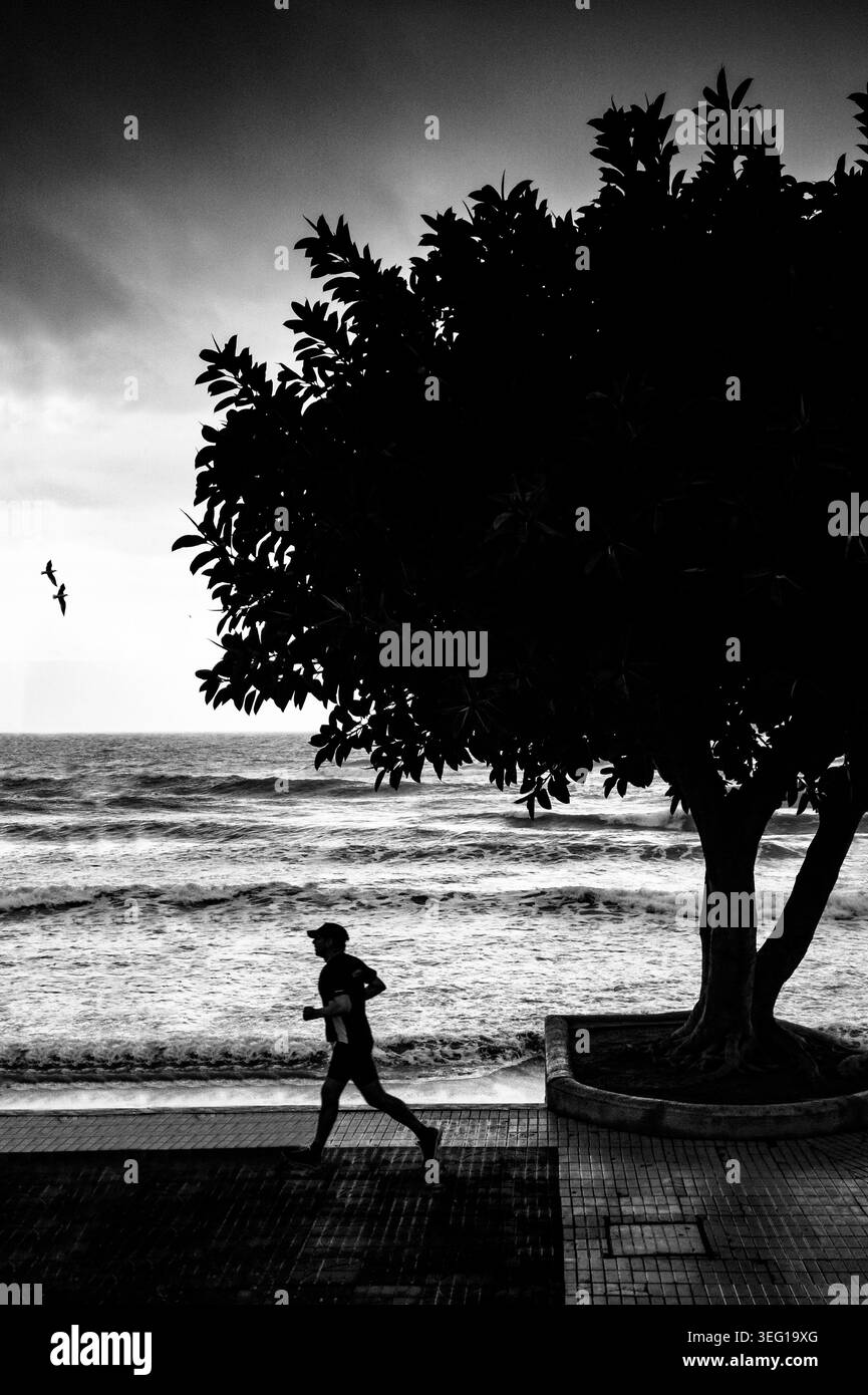 Jogging matinal au-dessus d'une plage orageuse Playa del Torrecilla, Nerja, Costa del sol, Province de Malaga, Andalousie, Espagne Banque D'Images
