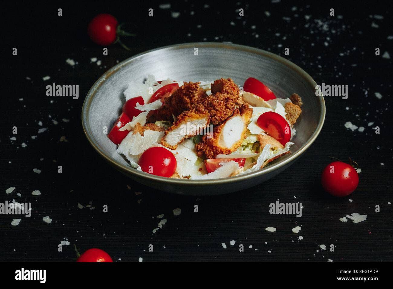 Délicieuse salade avec tomates cerises et garniture croquante dans un bol rustique Banque D'Images