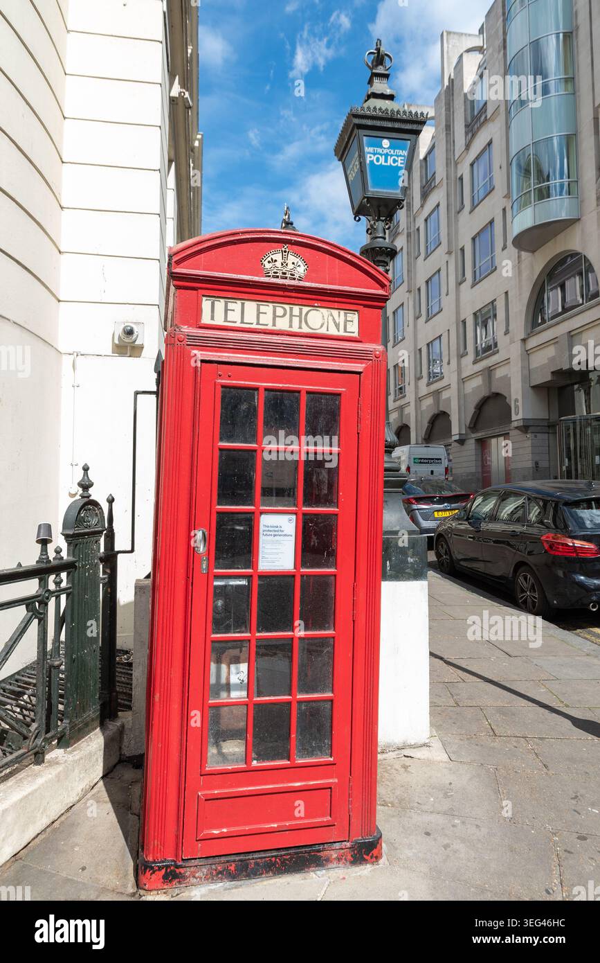 Cabine téléphonique rouge emblématique près du poste de police de Charing Cross, à Charing Cross, Westminster, Londres, Royaume-Uni, avec lanterne de police vintage Banque D'Images