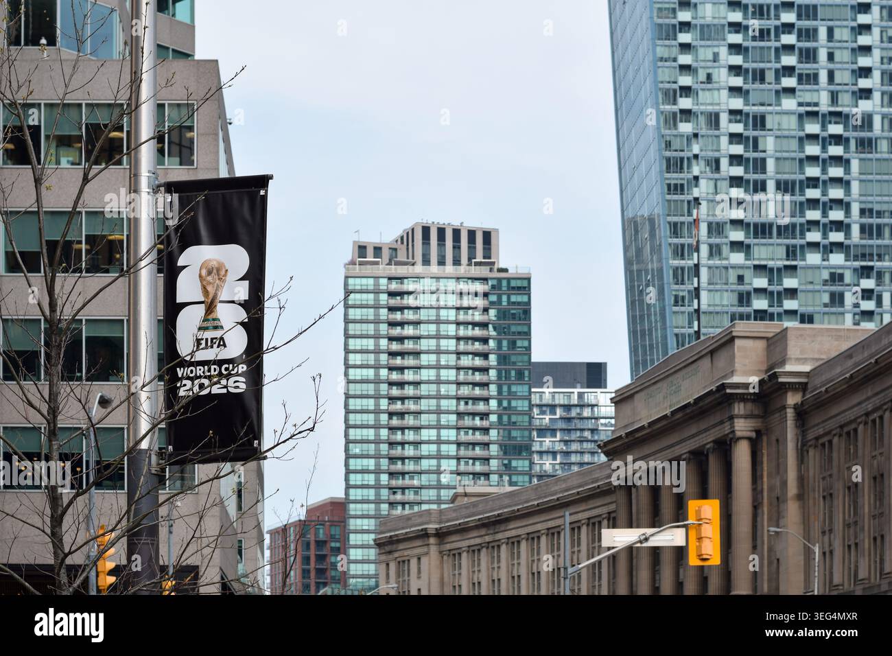 Toronto, Ontario, Canada - 17 mai 2026 : bannière verticale faisant la promotion de la Coupe du monde de la FIFA 2026 attachée à un poteau de rue dans le centre-ville urbain avec des offi modernes Banque D'Images