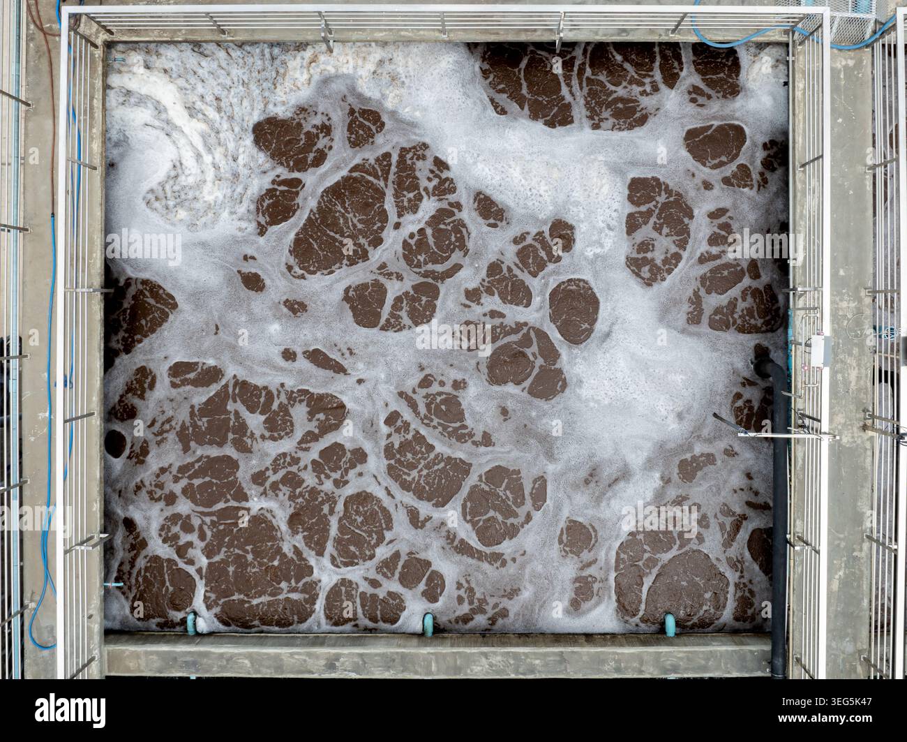 Vue surélevée d'un réservoir de traitement des eaux usées industrielles montrant le processus d'aération avec de la mousse dense pour la purification biologique. Banque D'Images