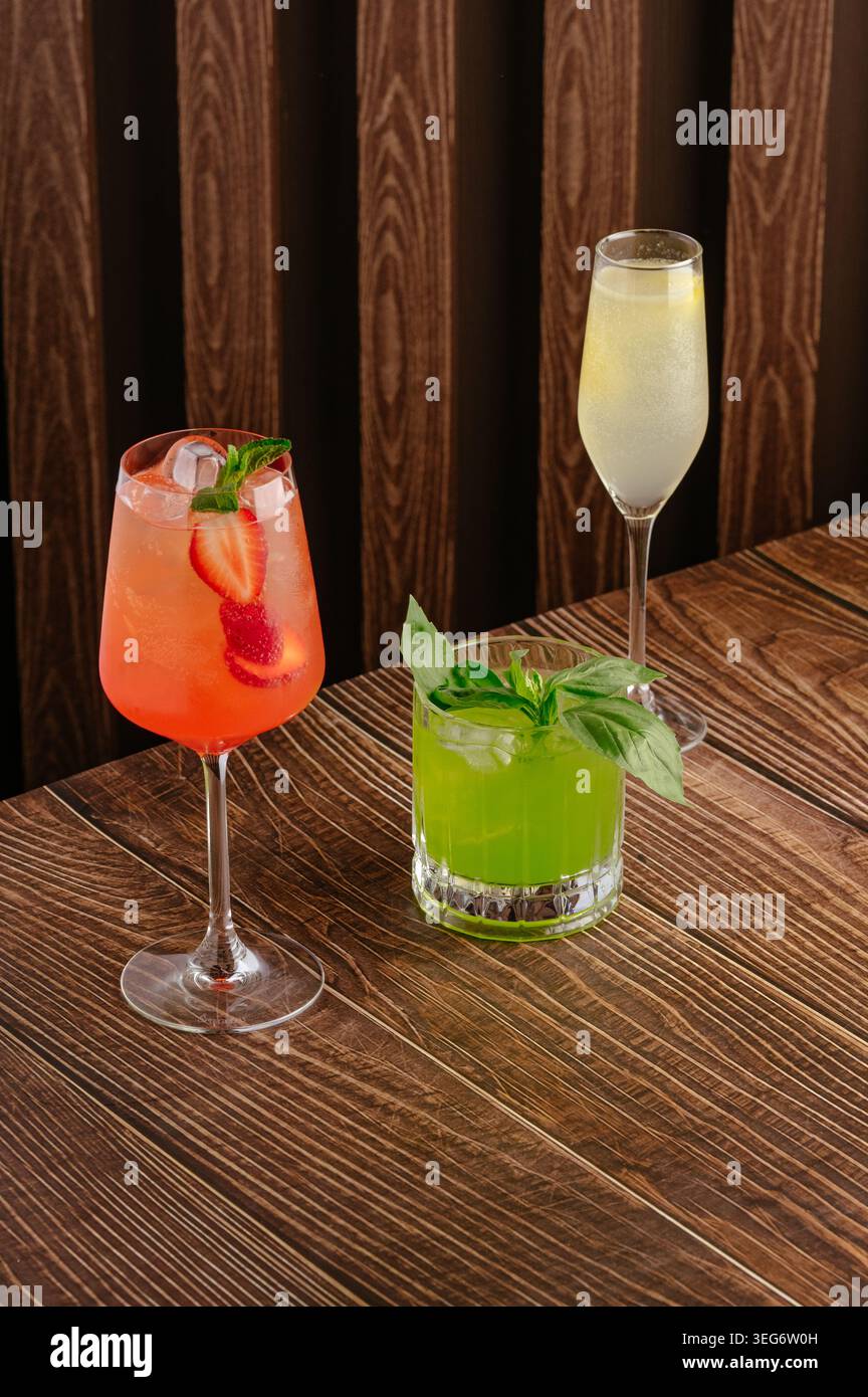 Trois cocktails assortis colorés sur une table en bois Banque D'Images