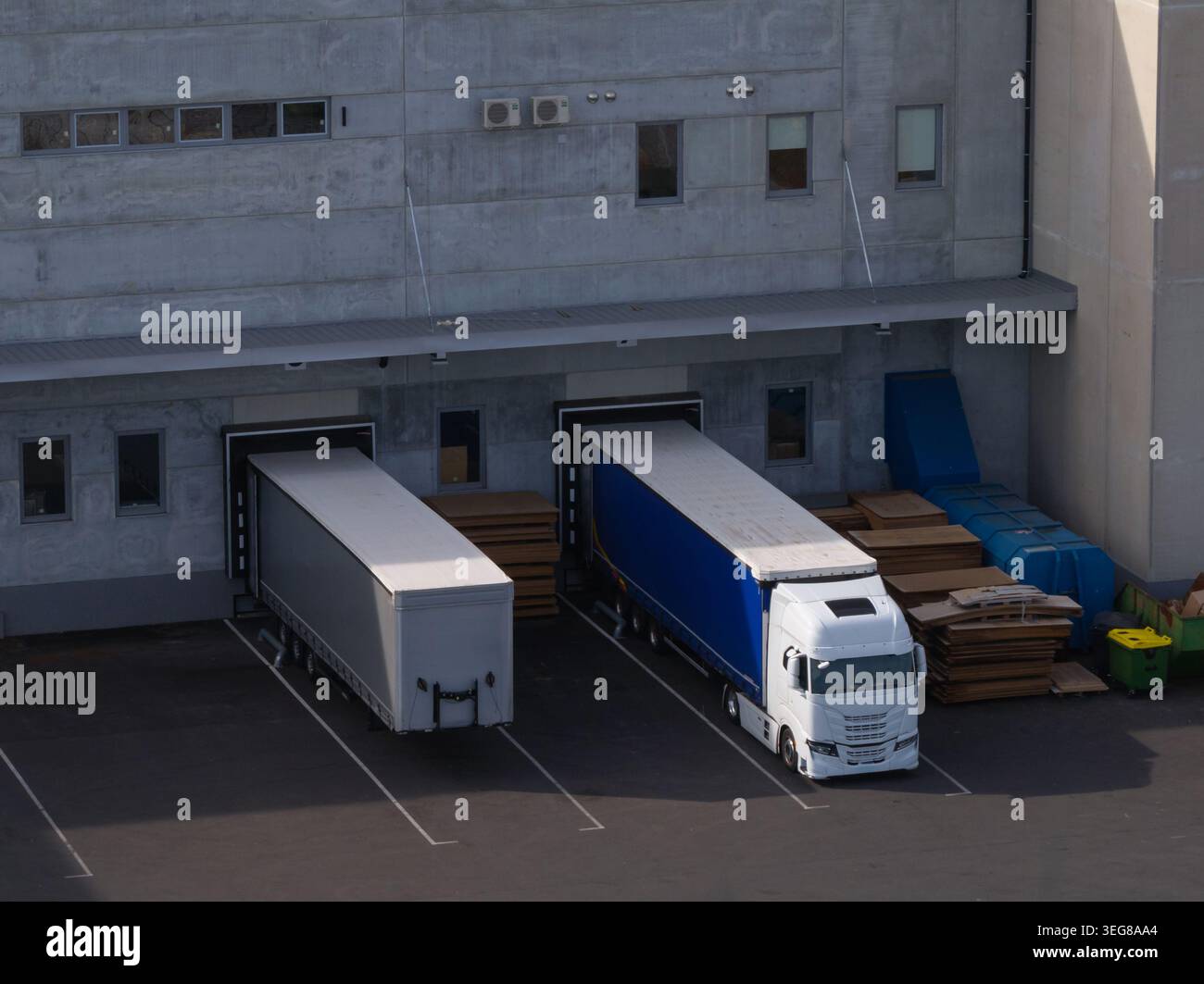 Les camions de fret sont stationnés aux quais de chargement d'un centre logistique pour la distribution de fret et les opérations de la chaîne d'approvisionnement. Banque D'Images